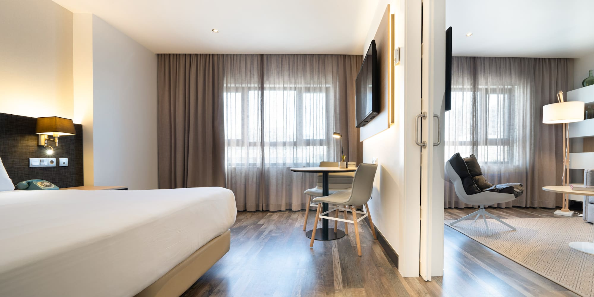 a room with a bed and a table and chairs