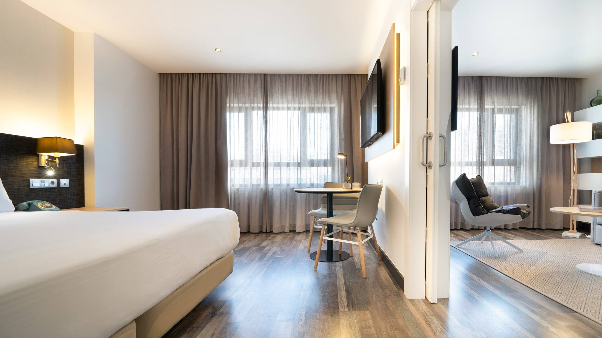 a room with a bed and a table and chairs