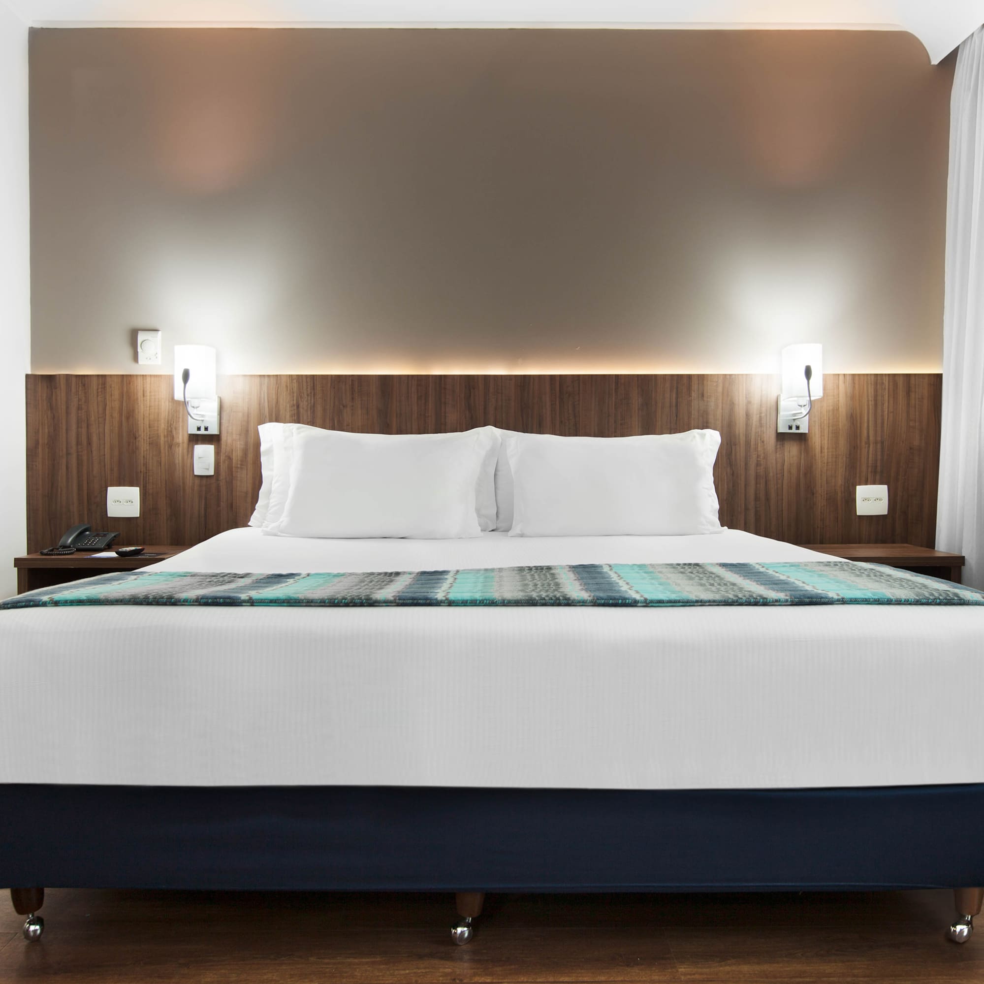 a bed with white pillows and a blue blanket