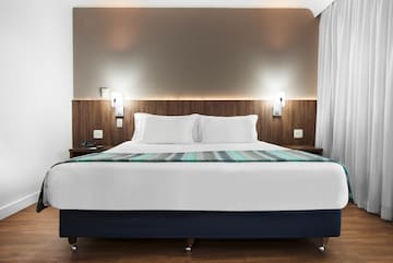 a bed with white pillows and a blue blanket