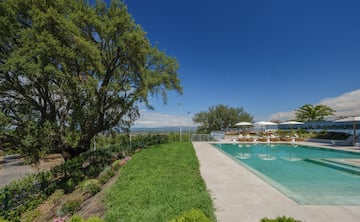 a pool with grass and umbrellas