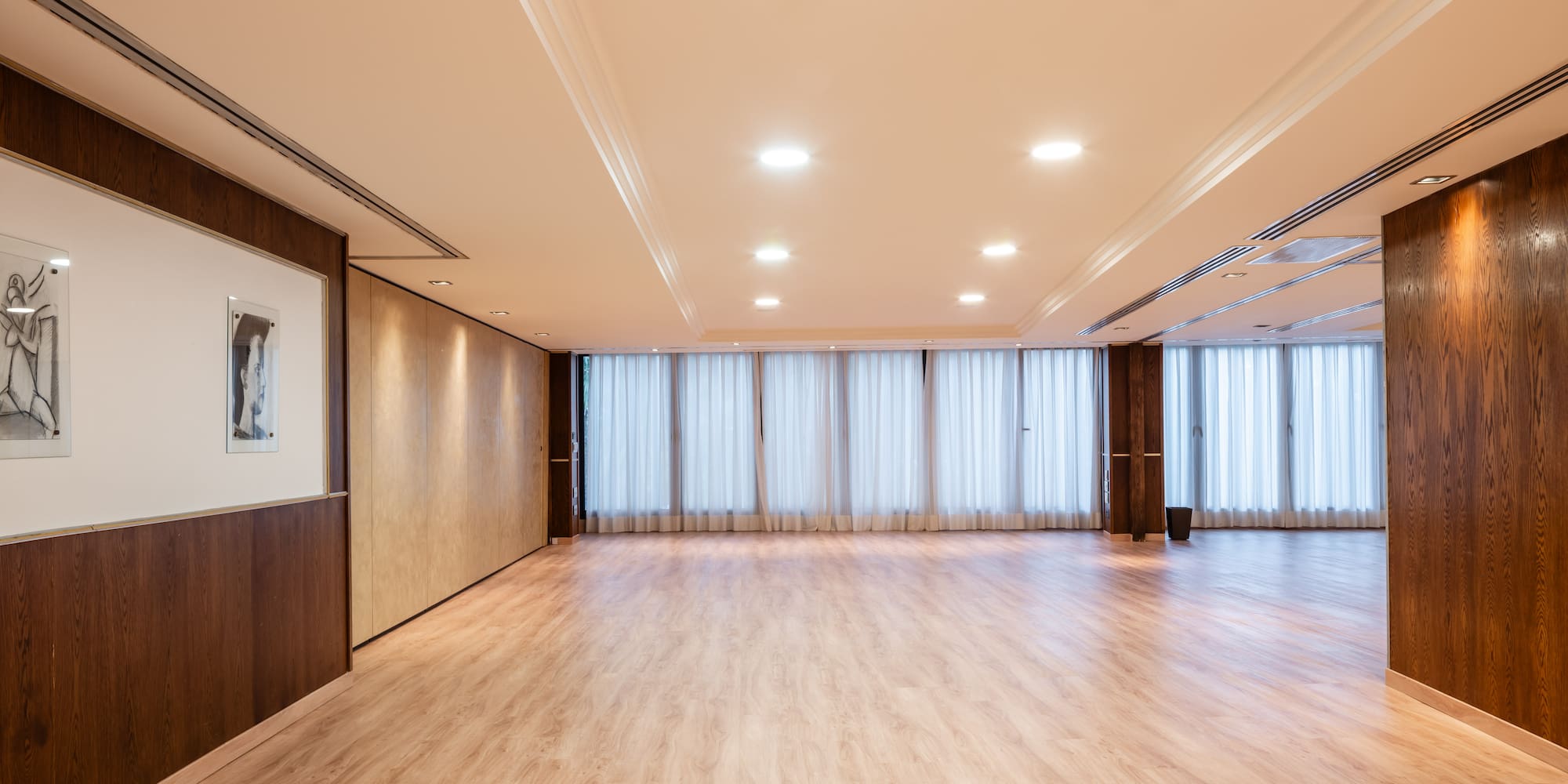 a room with a wood floor and white curtains