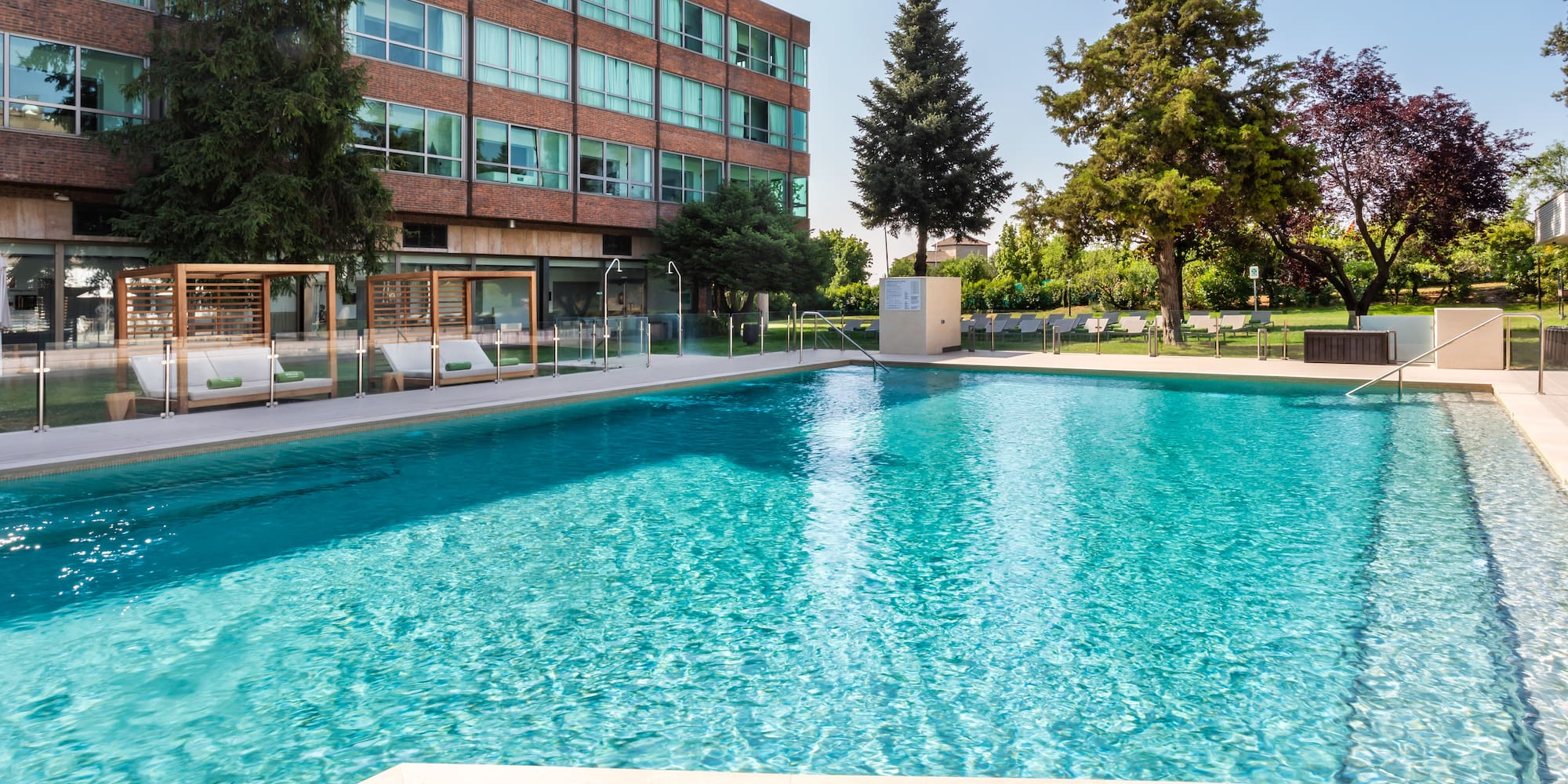 a pool with trees and buildings in the background