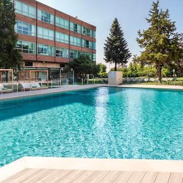 a pool with trees and buildings in the background