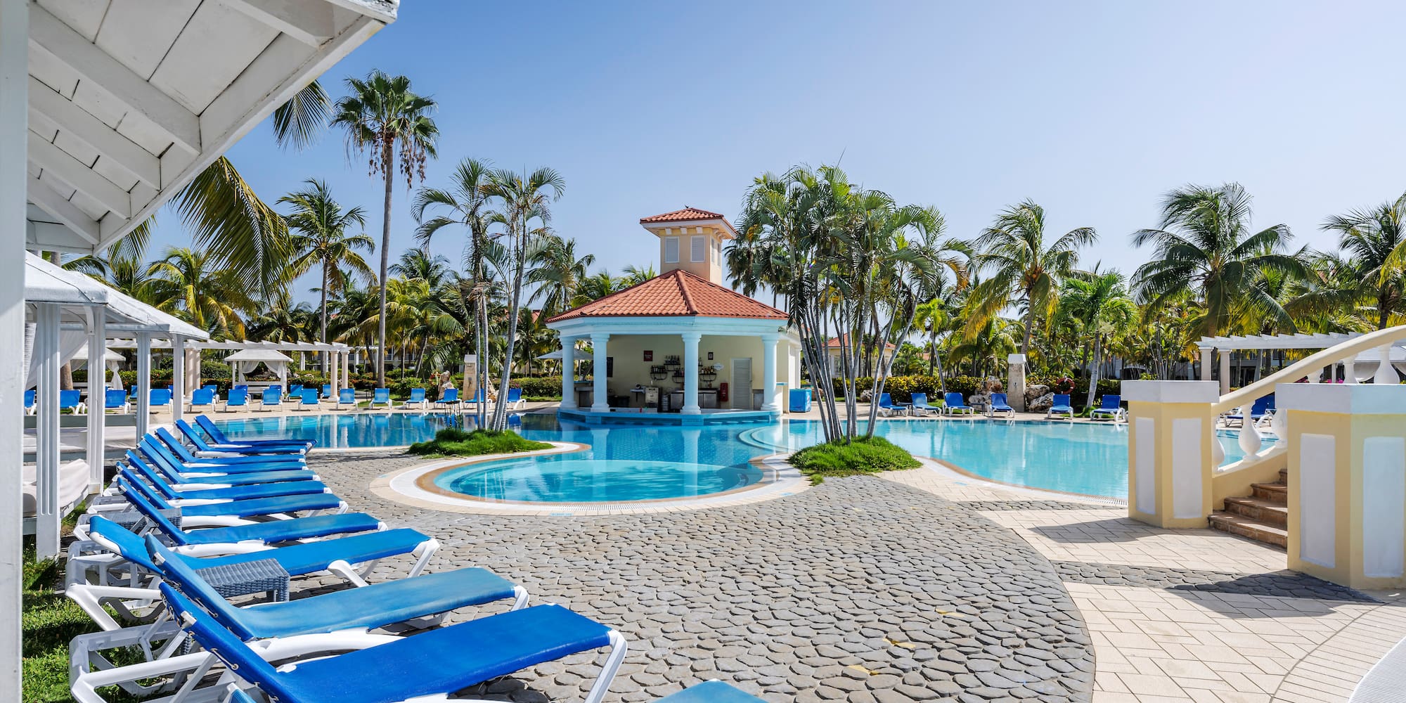a pool with lounge chairs and a gazebo