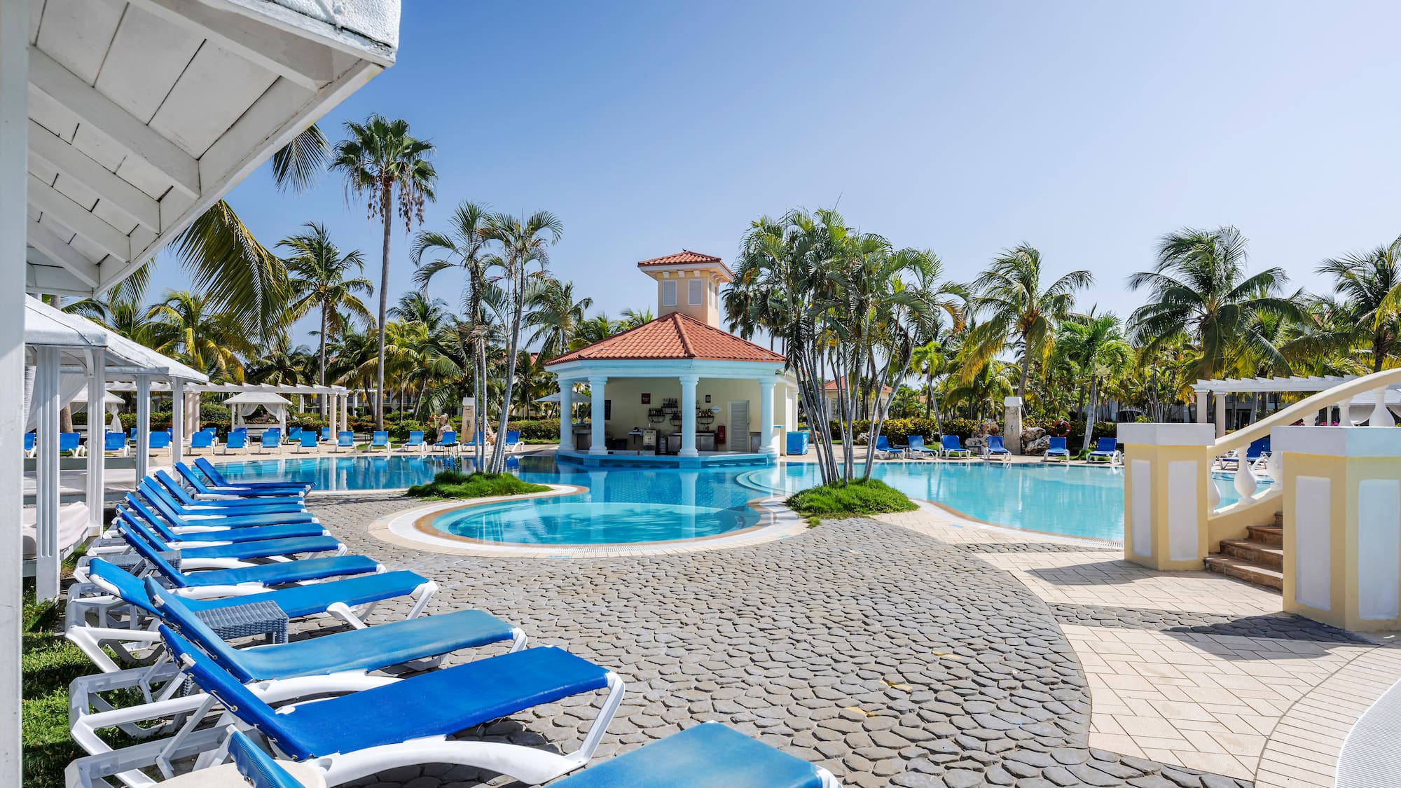 a pool with lounge chairs and a gazebo