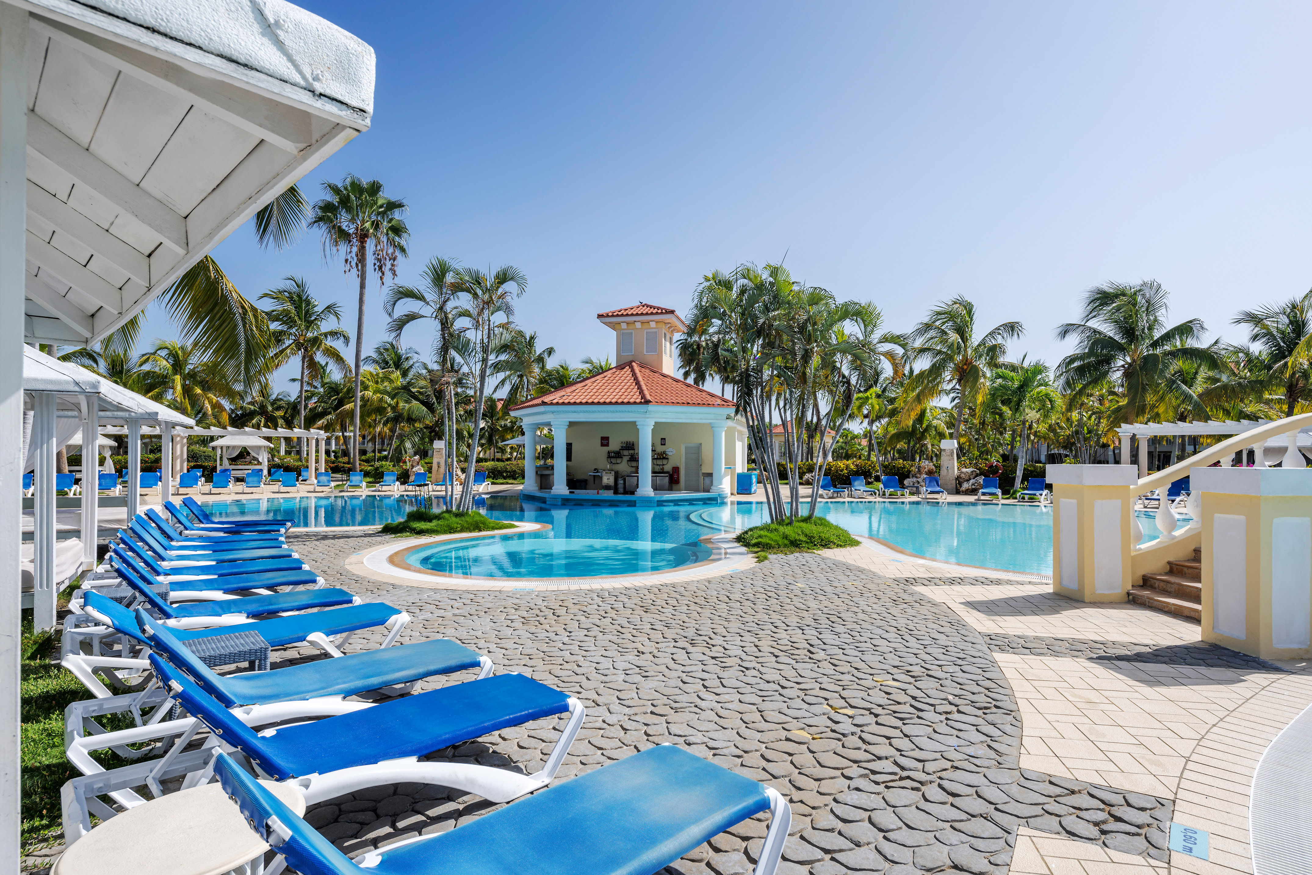 a pool with lounge chairs and a gazebo