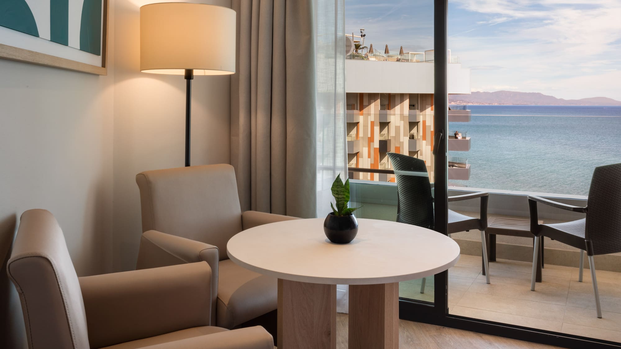 a room with a table and chairs and a lamp