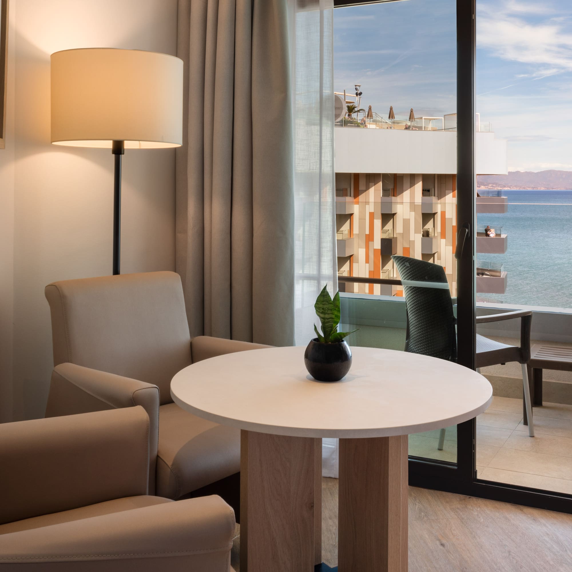 a room with a table and chairs and a lamp