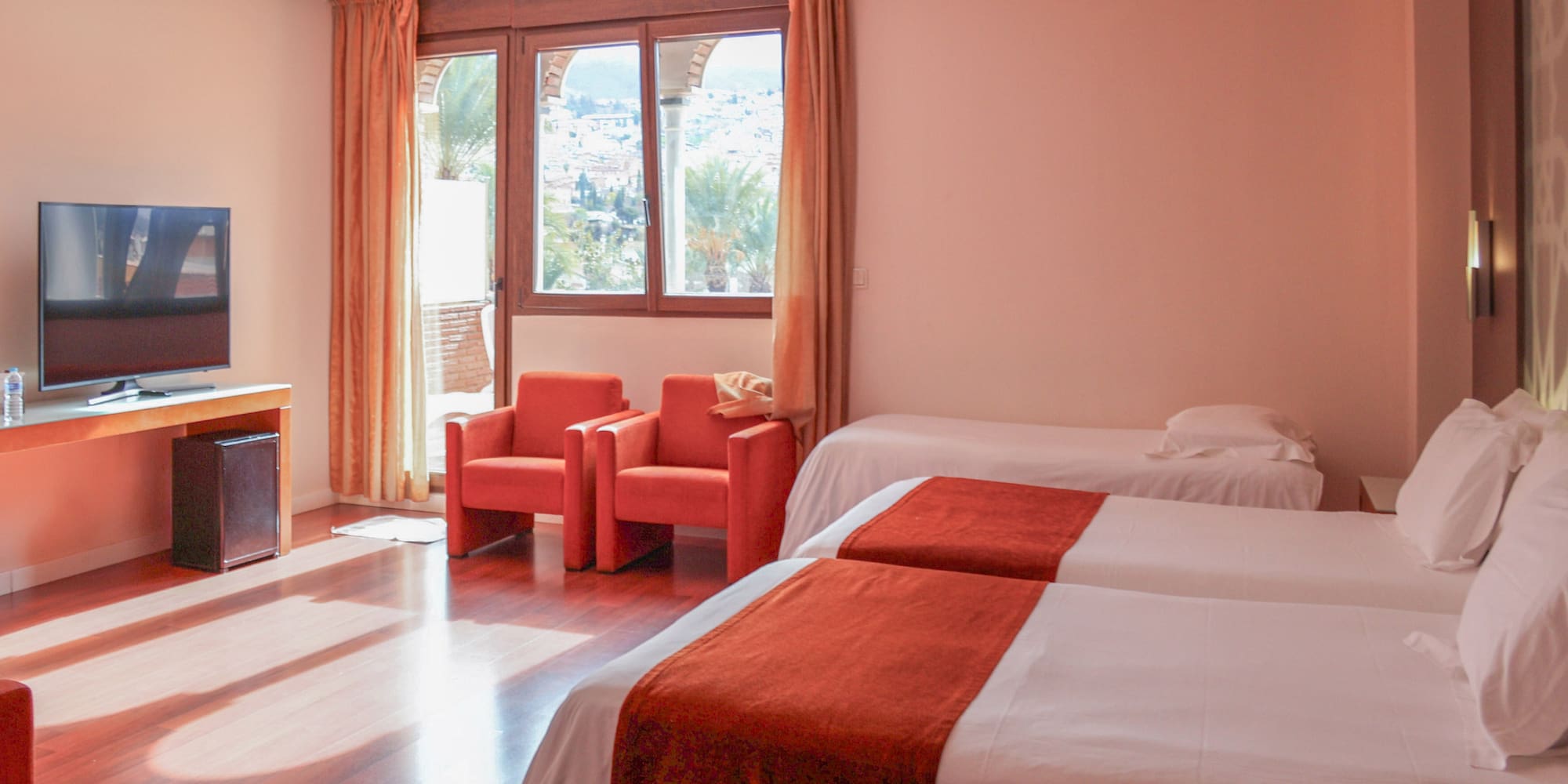 a room with two beds and chairs