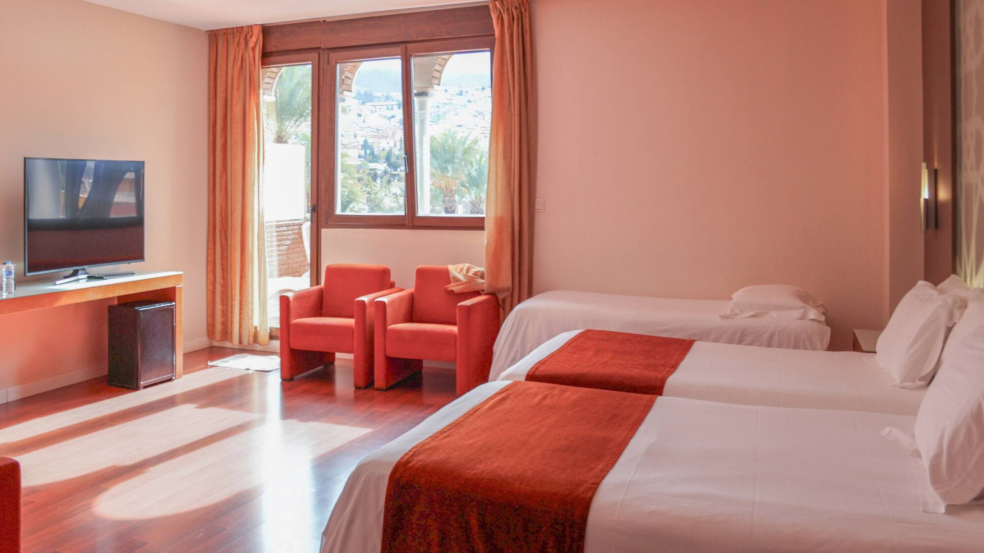 a room with two beds and chairs