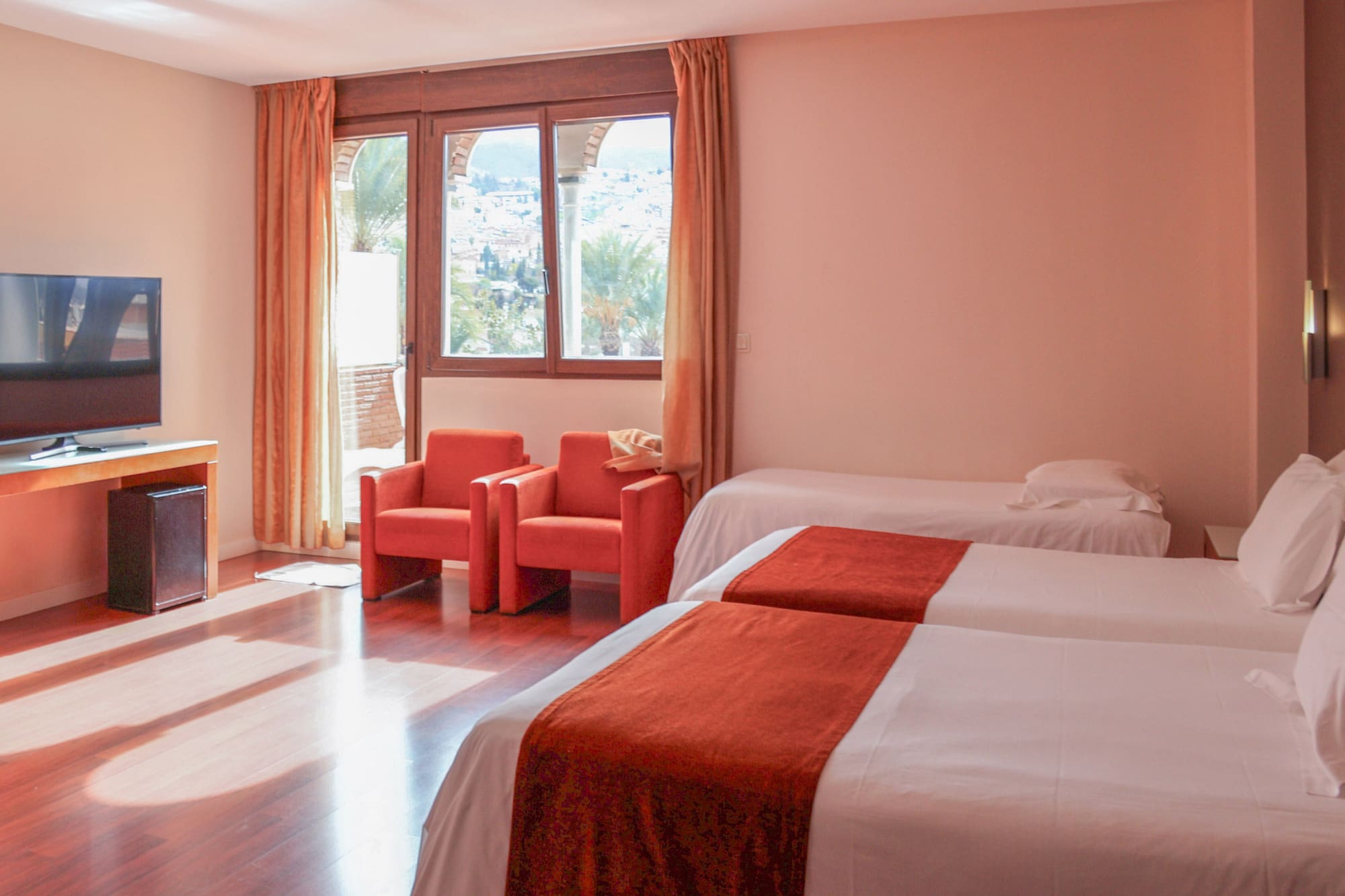 a room with two beds and chairs