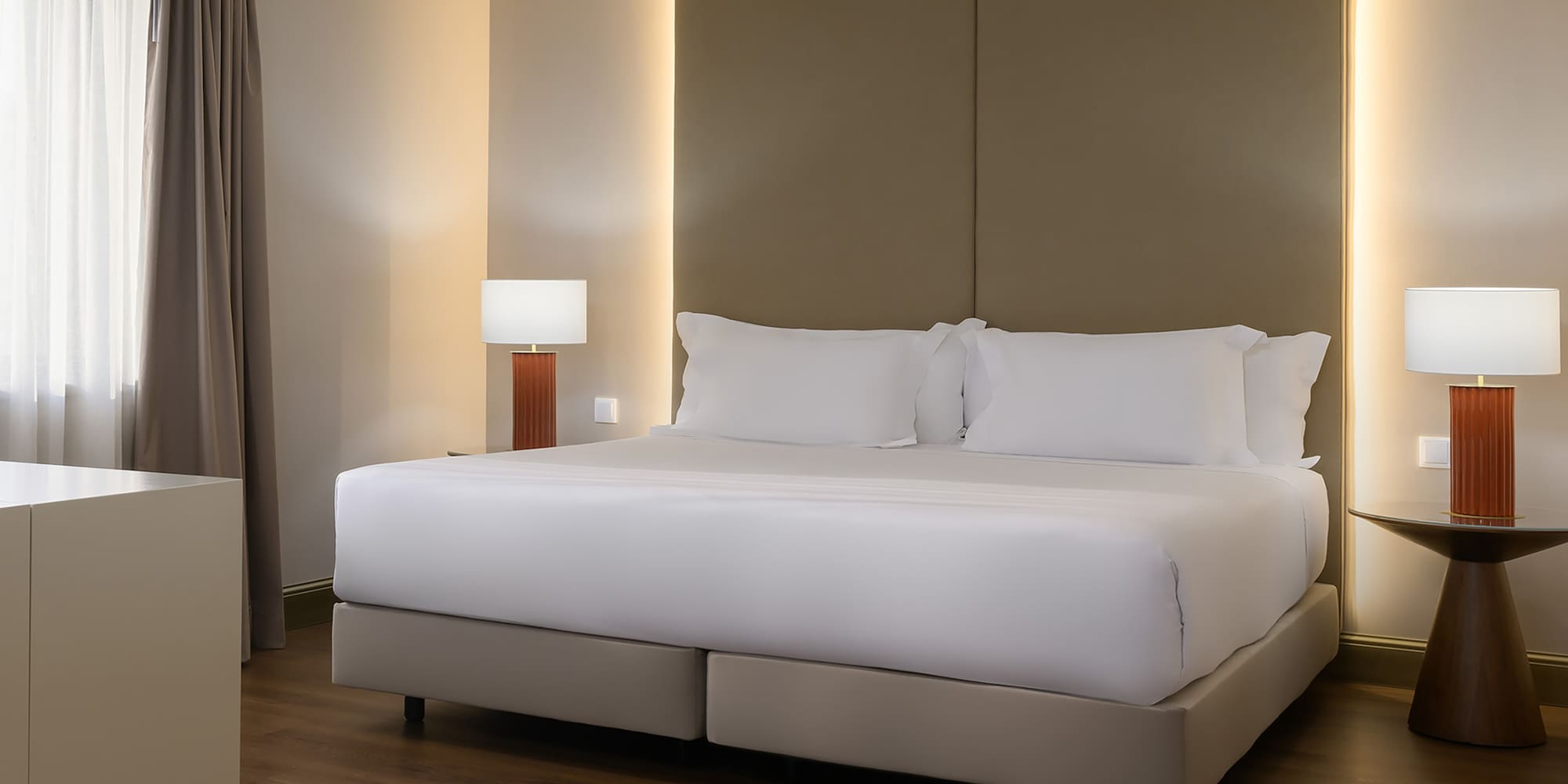 a bed with white sheets and a lamp