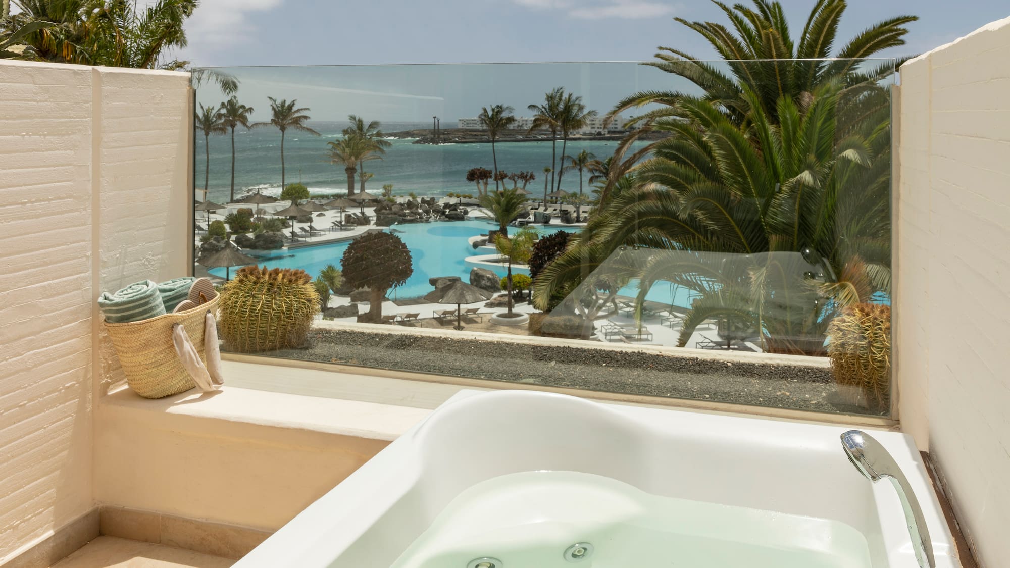 a hot tub with a view of the ocean and palm trees