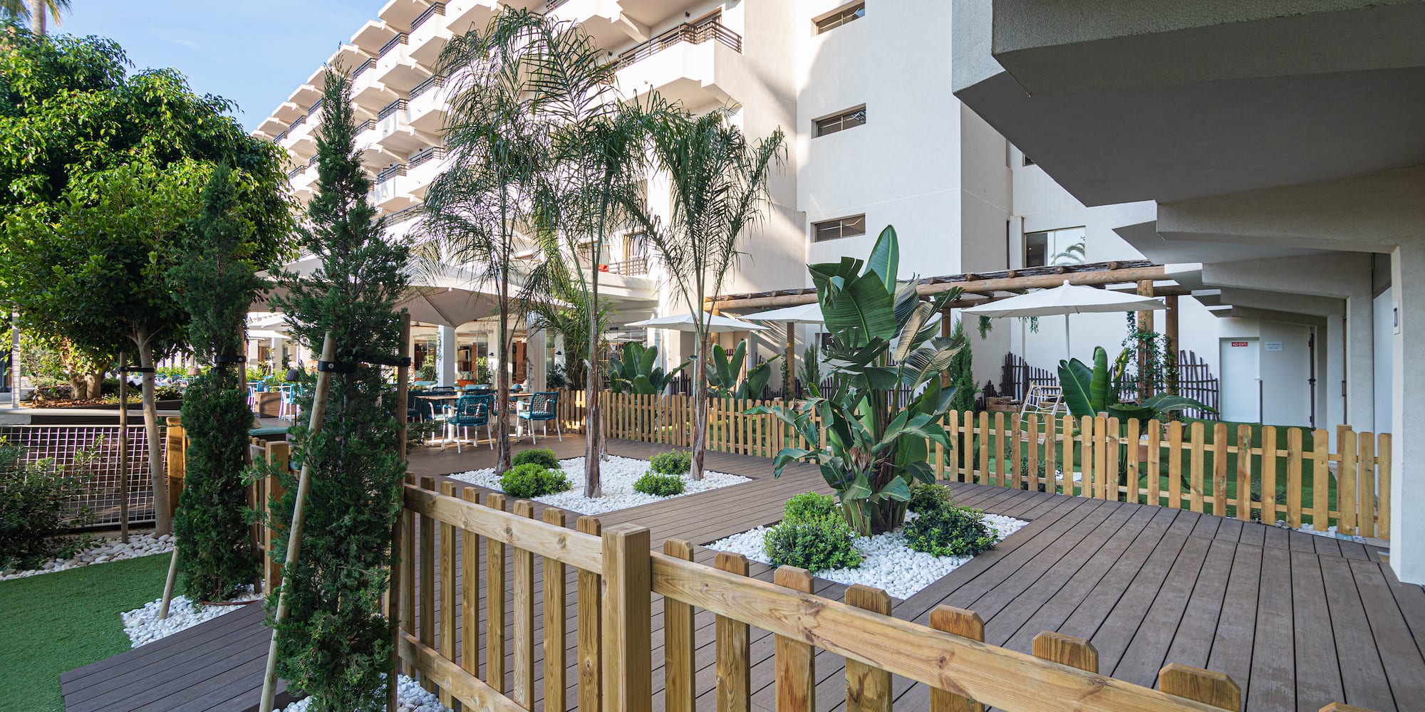 a wooden deck with trees and a fence in front of a building