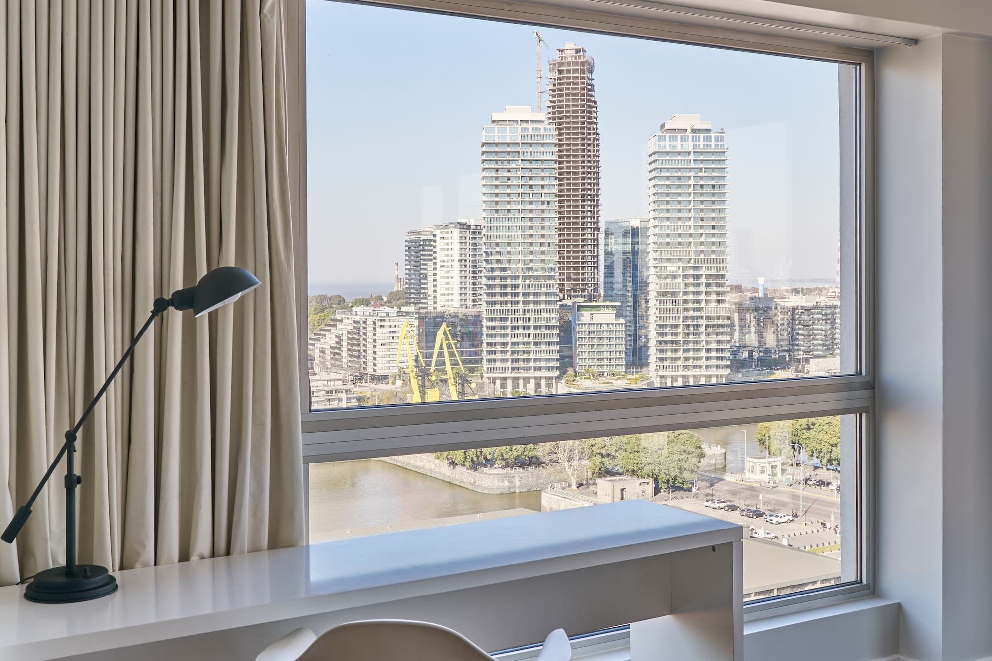 a desk and chair in a room with a large window