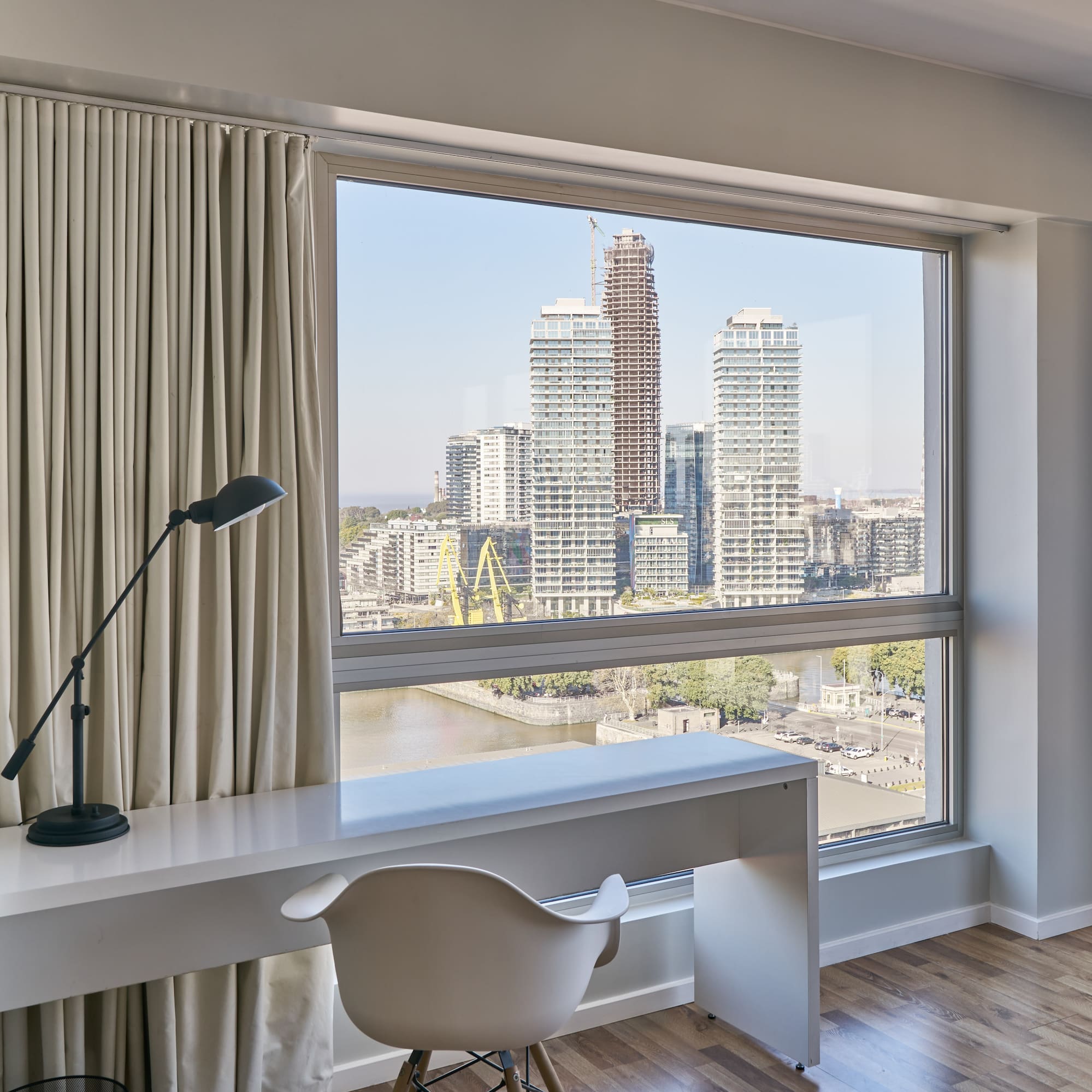 a desk and chair in a room with a large window