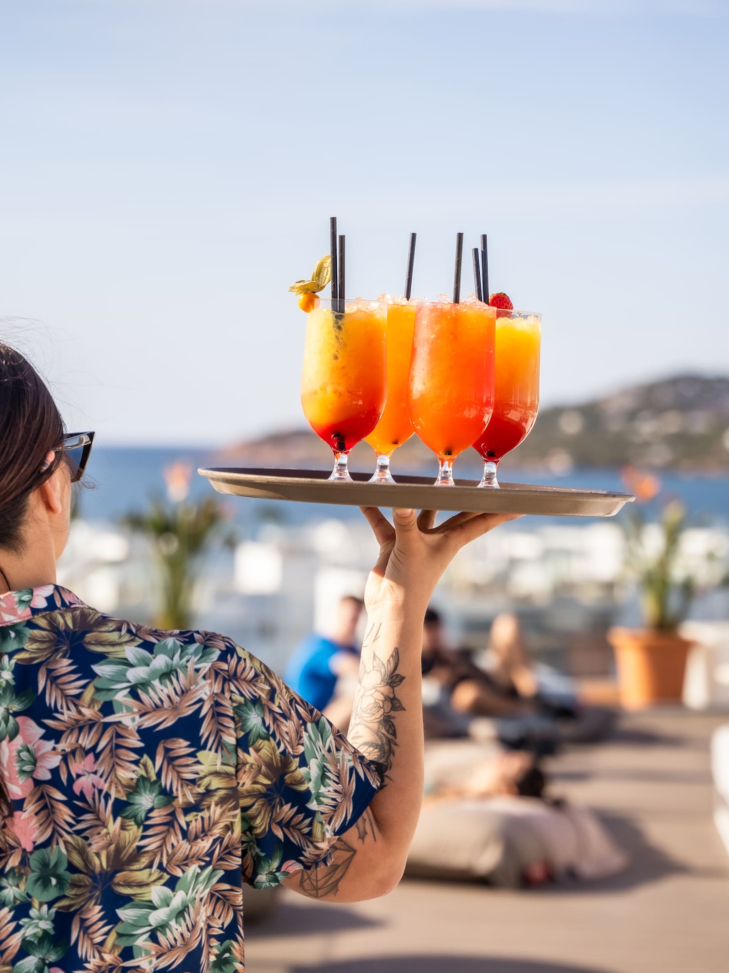 a woman holding a tray of drinks