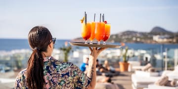 a woman holding a tray of drinks