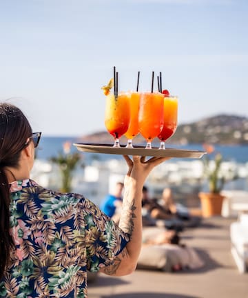 a woman holding a tray of drinks