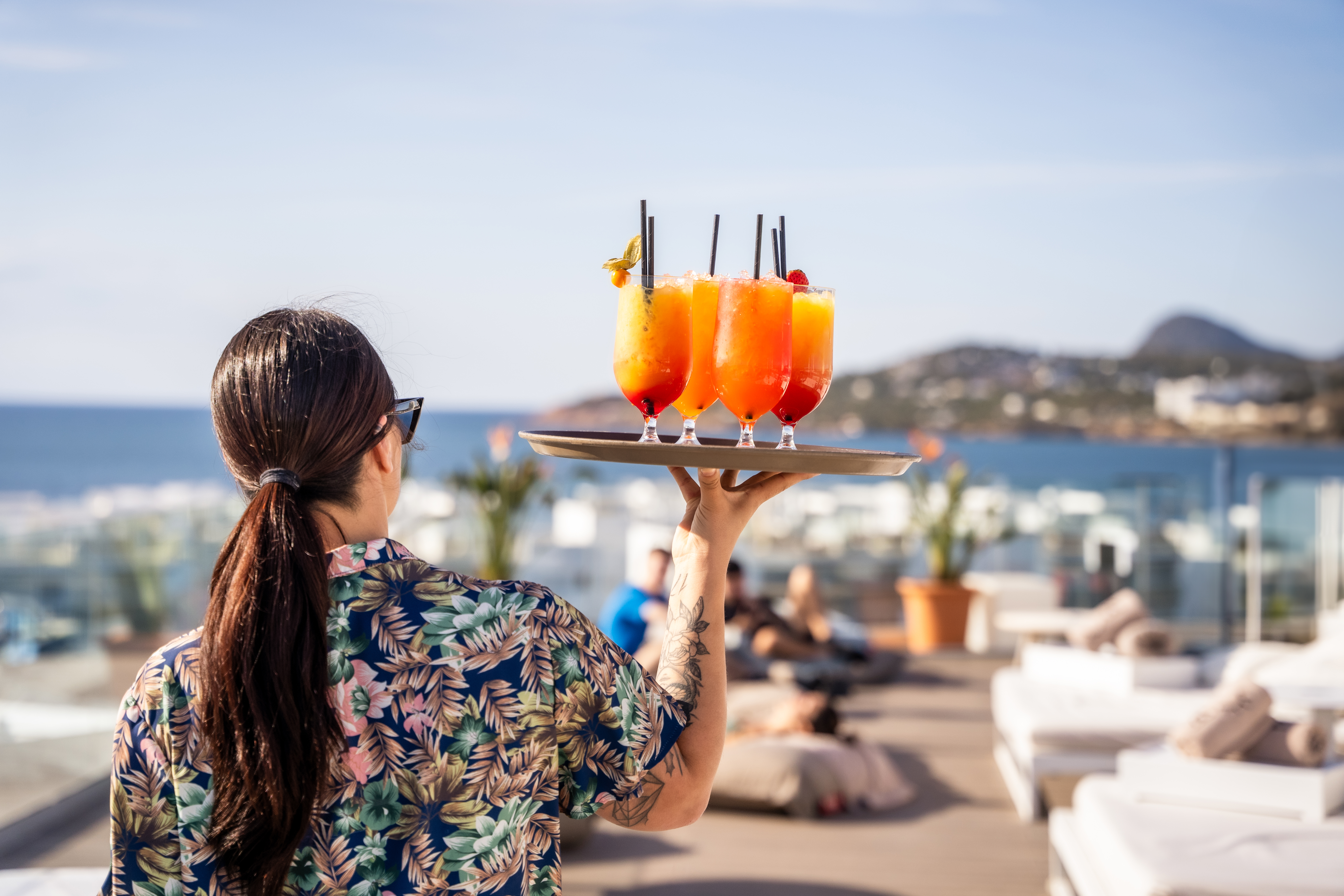 a woman holding a tray of drinks