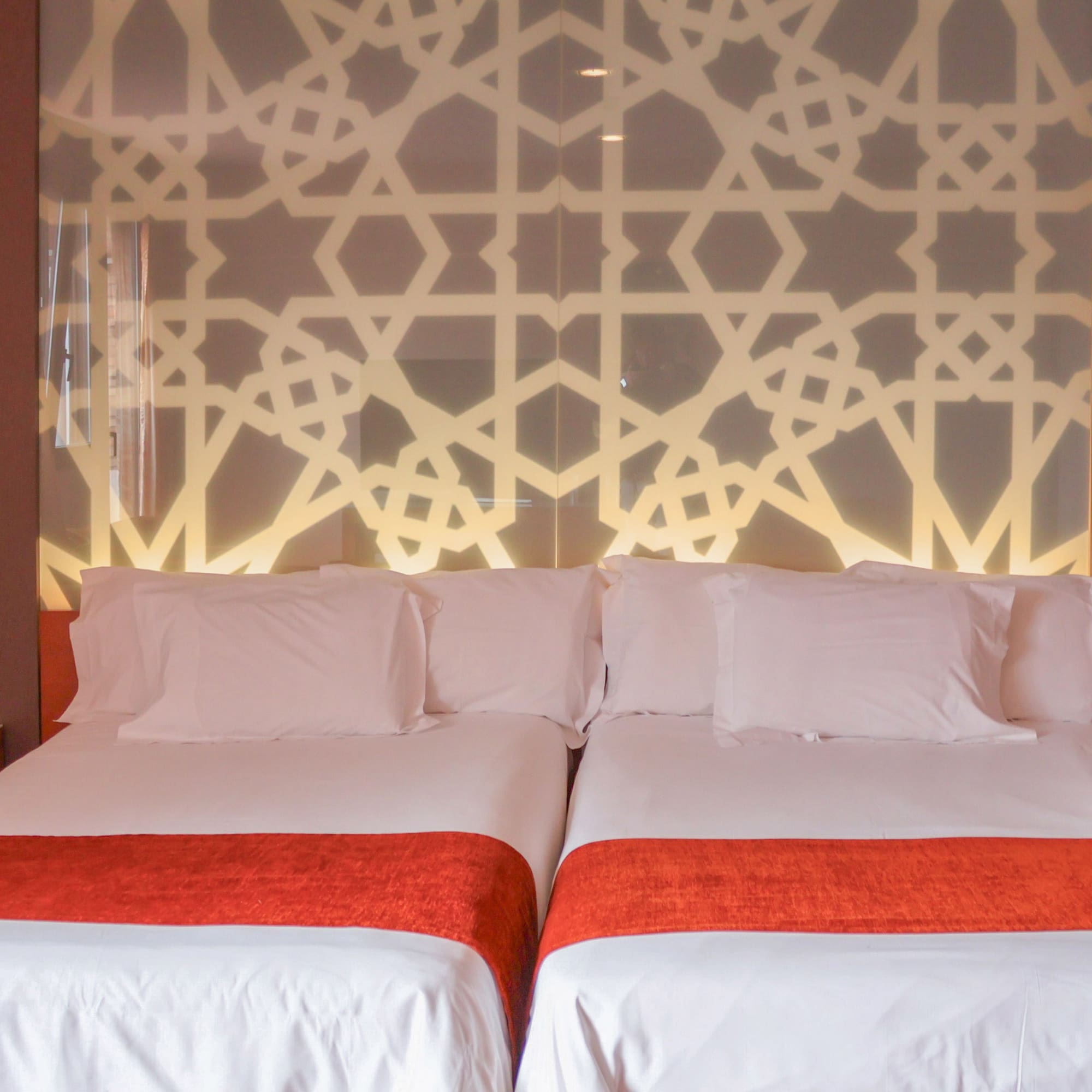 a bed with white sheets and red blankets