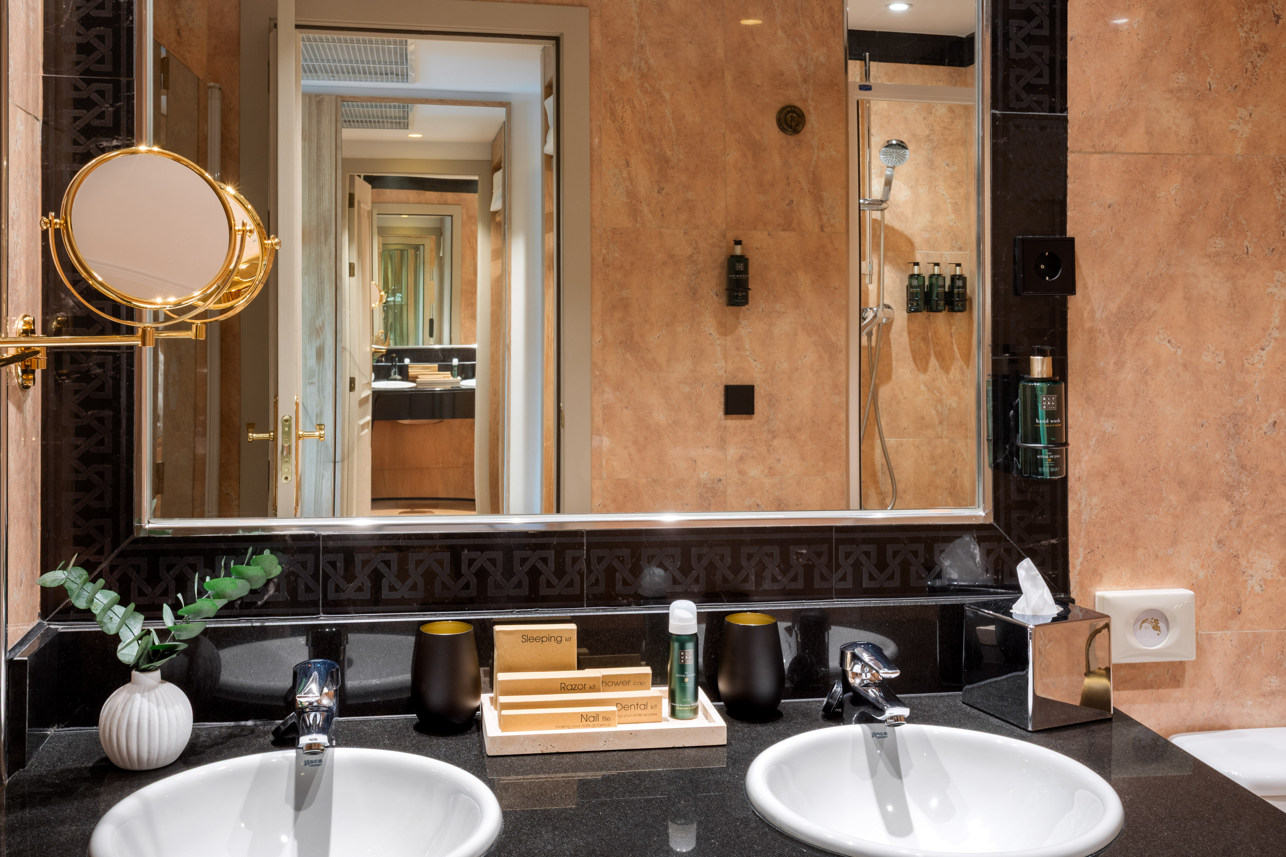 Luxury hotel bathroom with double vanity, large mirror, and premium amenities.