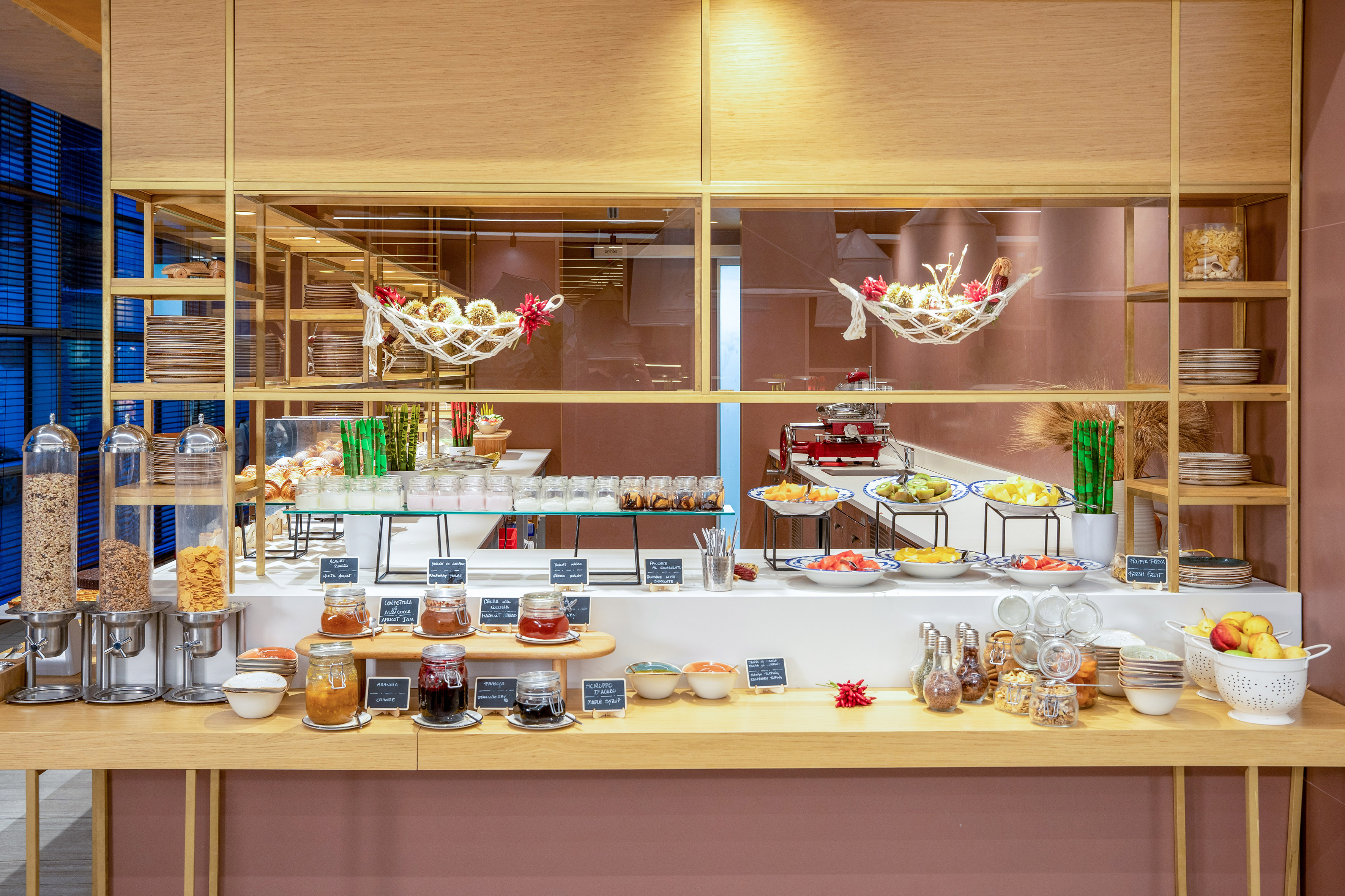 Hotel breakfast buffet: cereals, jams, fresh fruit, and pastries.