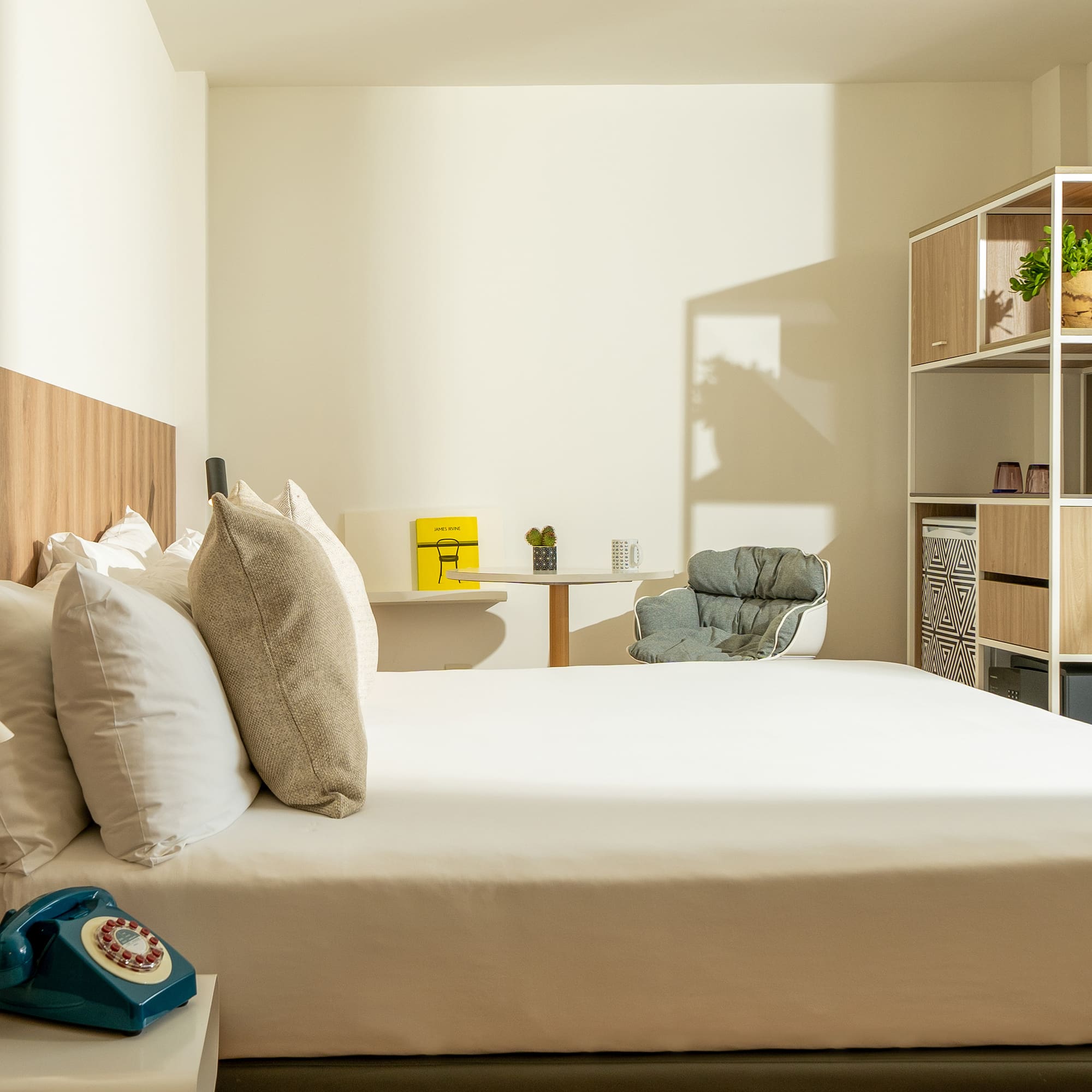 a bed with pillows and a chair in a room