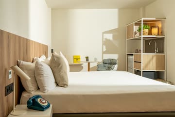 a bed with pillows and a chair in a room