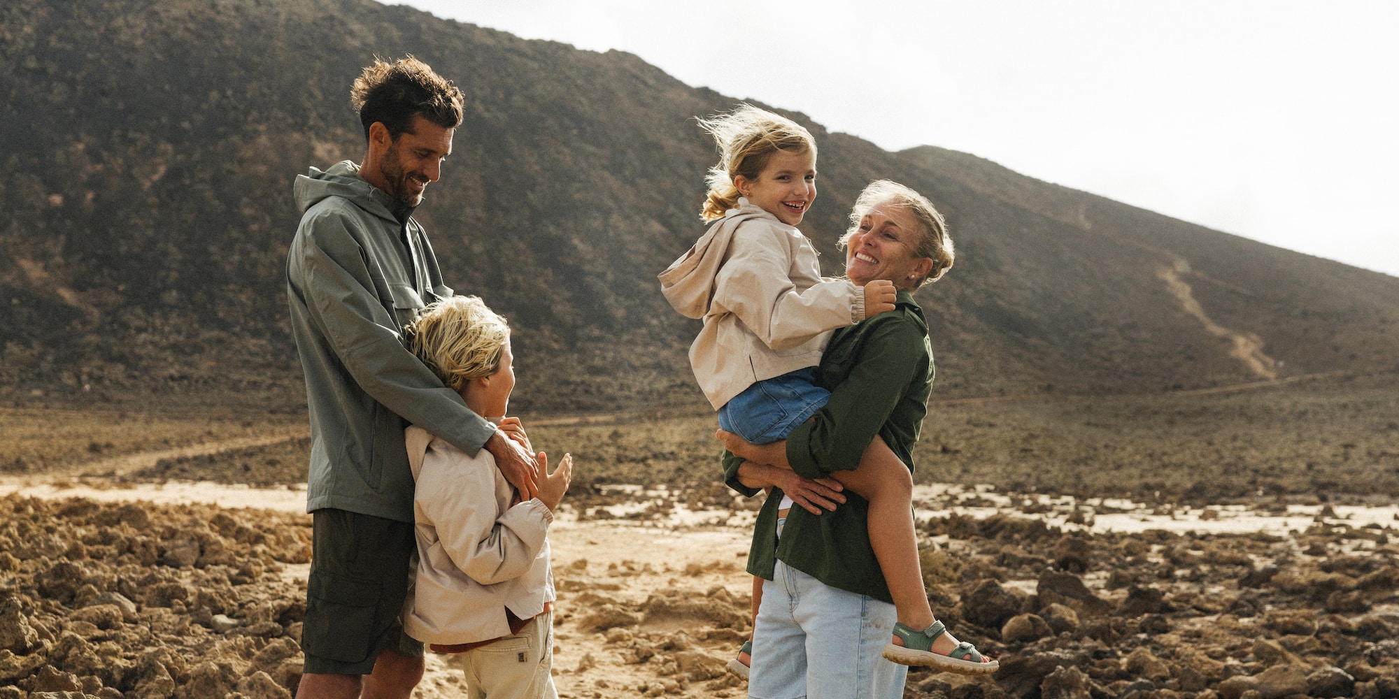 a man holding a woman and two children