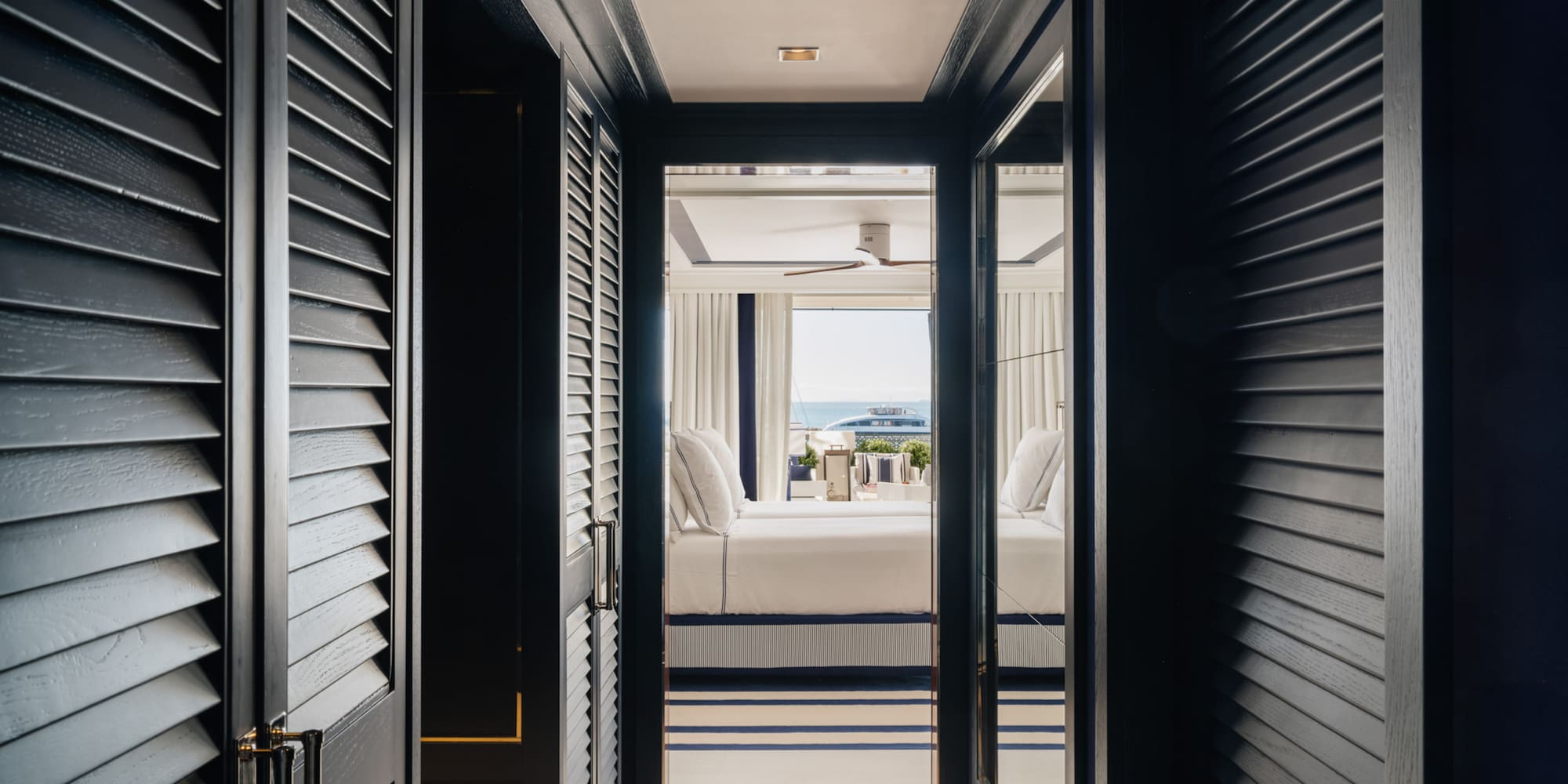 a hallway with a bed and a window