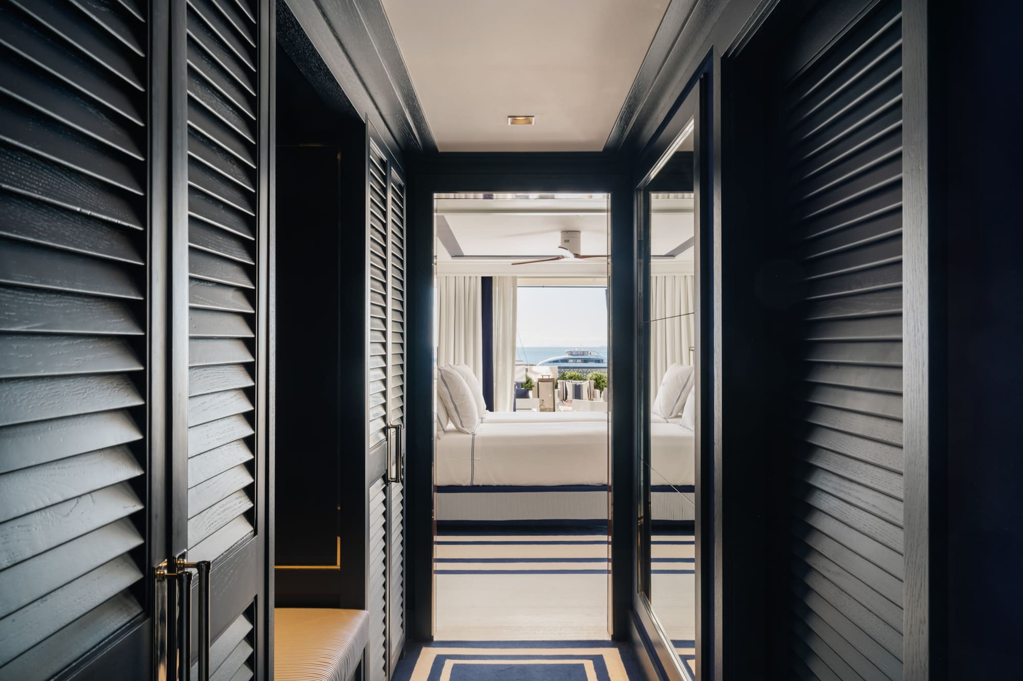 a hallway with a bed and a window