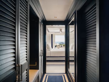 a hallway with a bed and a window