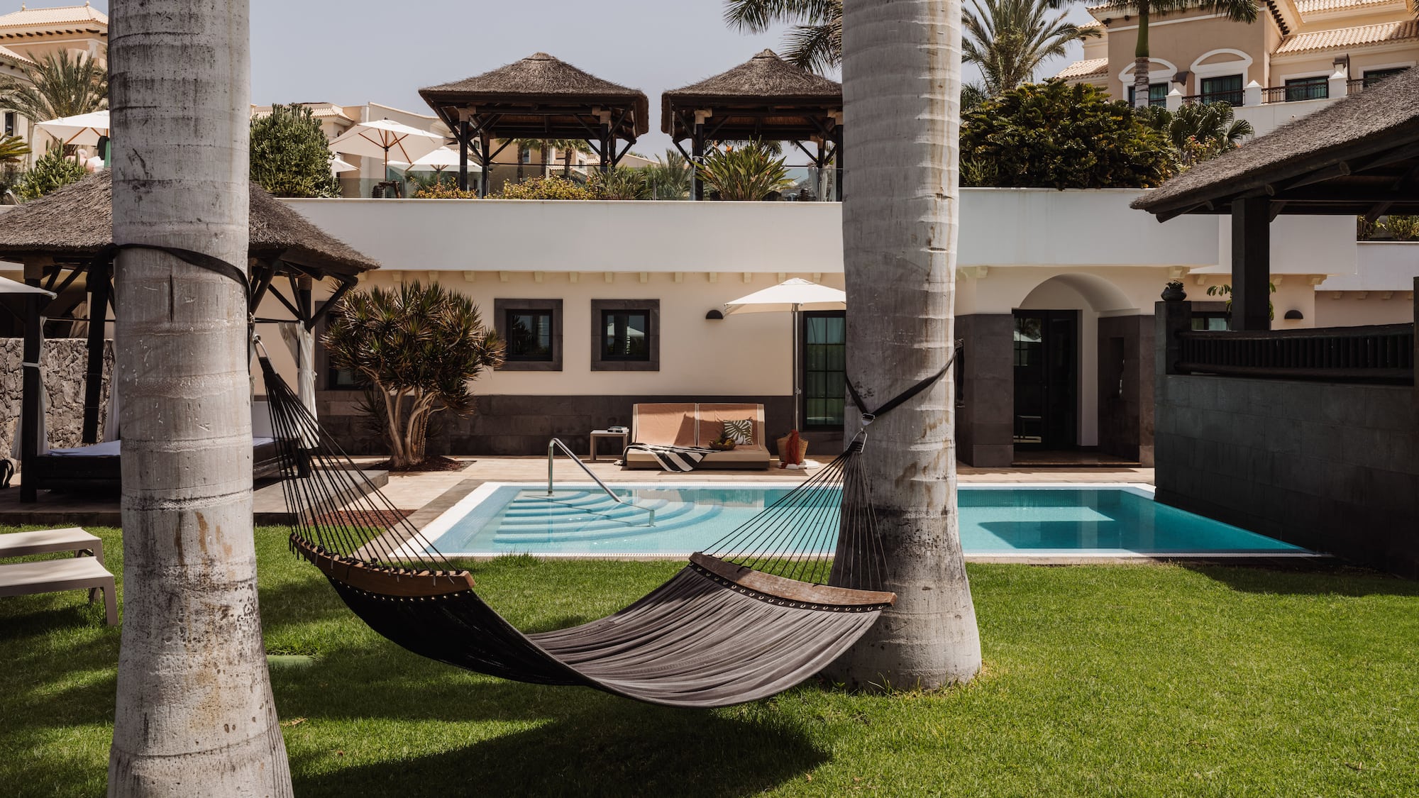 a hammock between two trees in a yard of a house