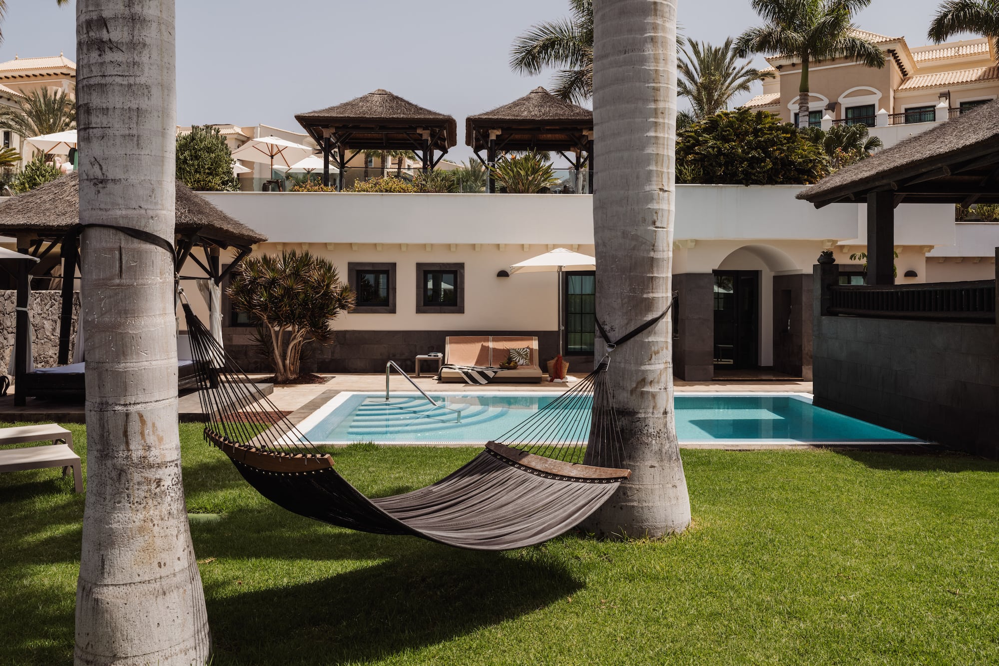 a hammock between two trees in a yard of a house