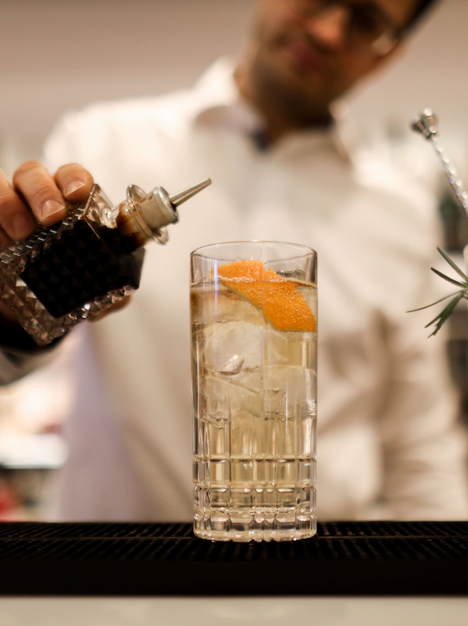 a person pouring a drink into a glass