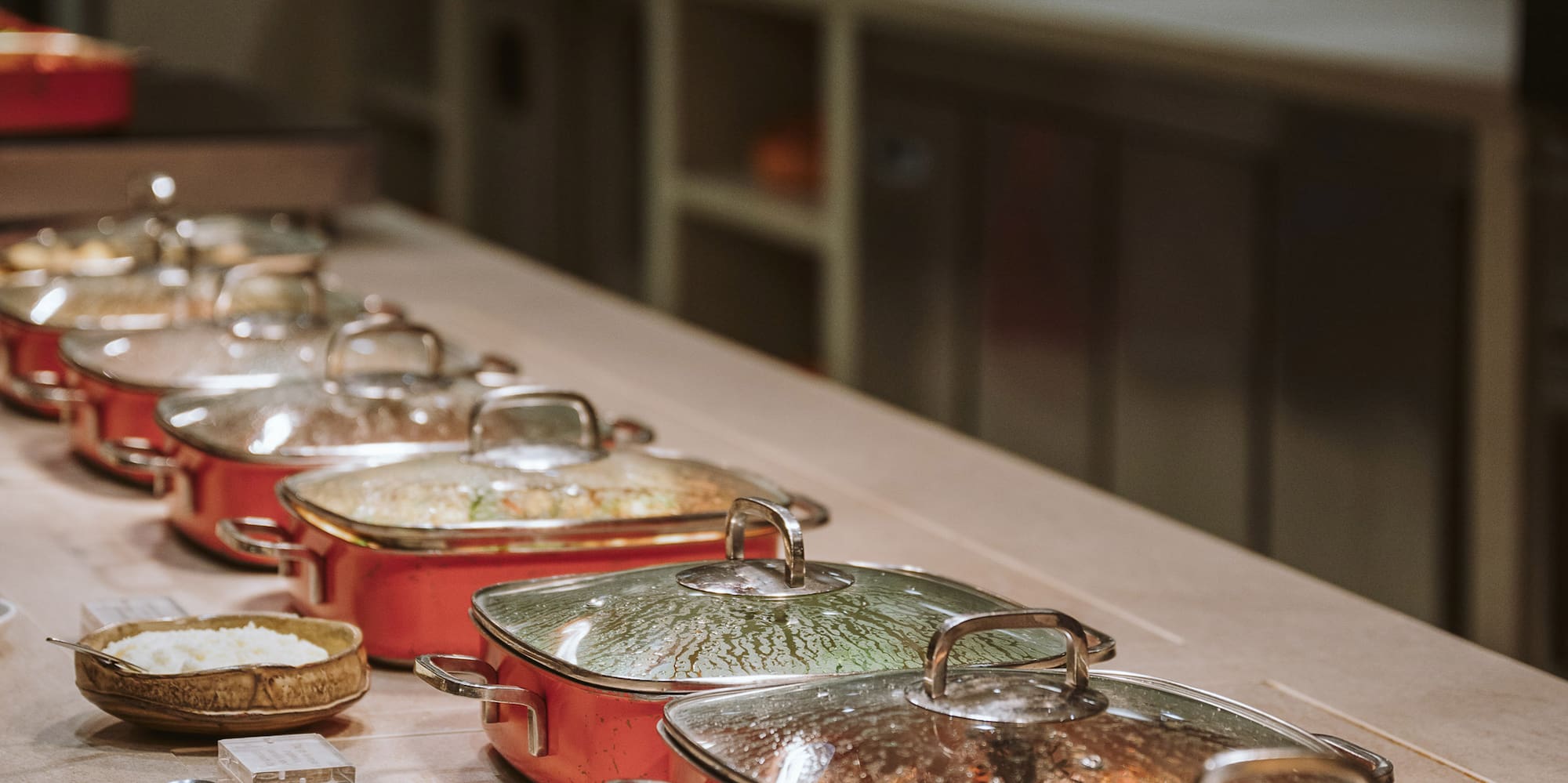 a row of pots with food on a table