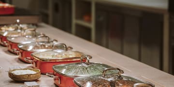 a row of pots with food on a table