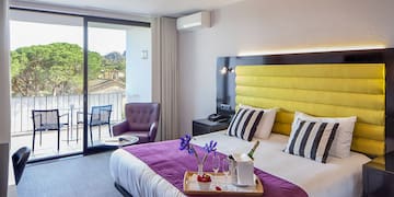 a room with a bed and a table with chairs and a glass door