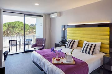 a room with a bed and a table with chairs and a glass door