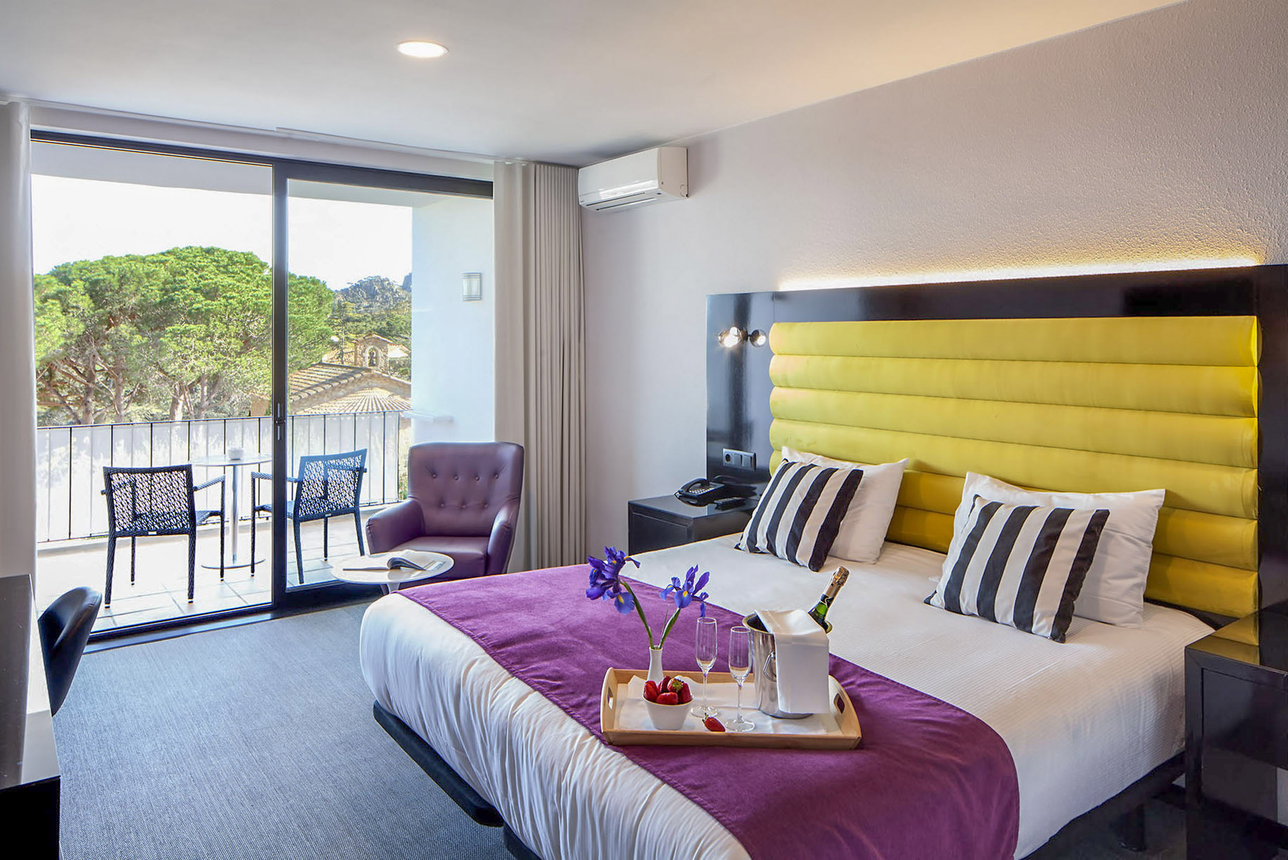 a room with a bed and a table with chairs and a glass door