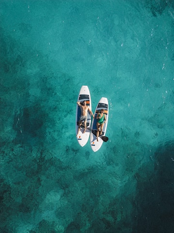 a couple of people on surfboards in the water