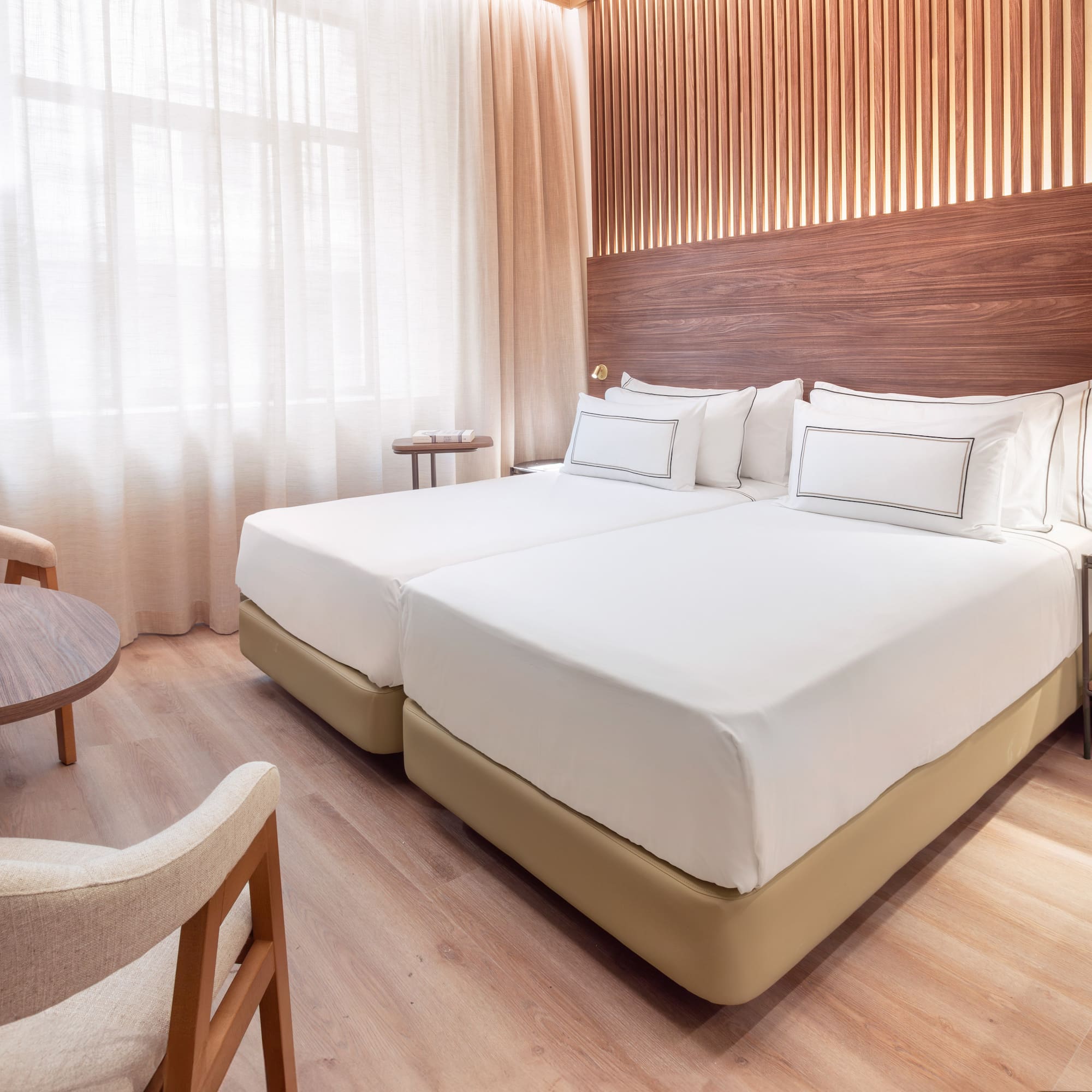 a room with two beds and a table