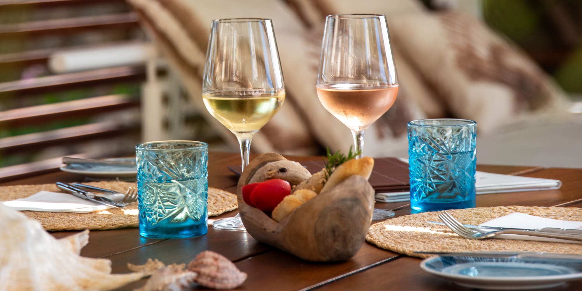 a table with glasses of wine and a bowl of food