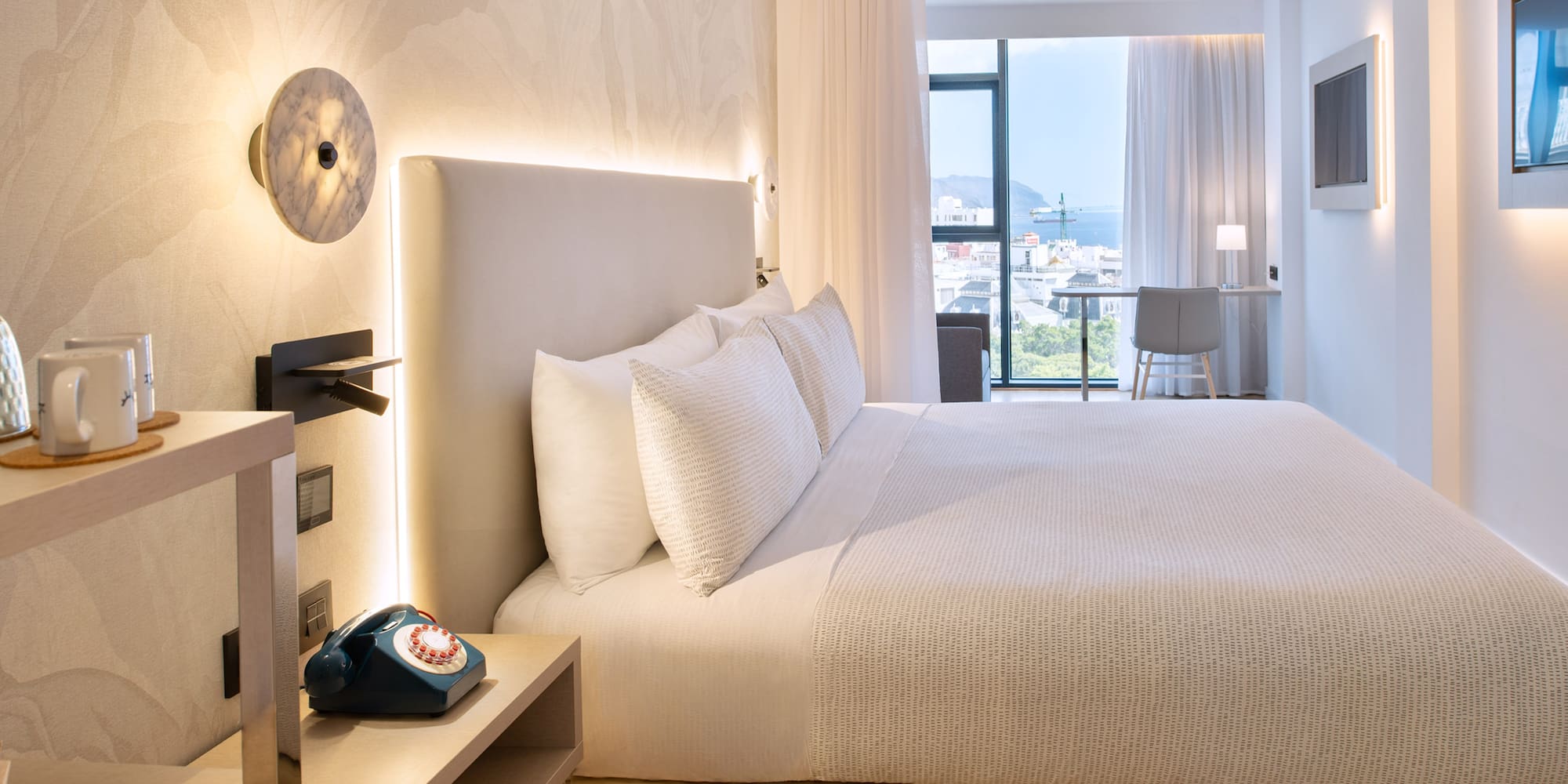 a bed with a telephone and a table in a room