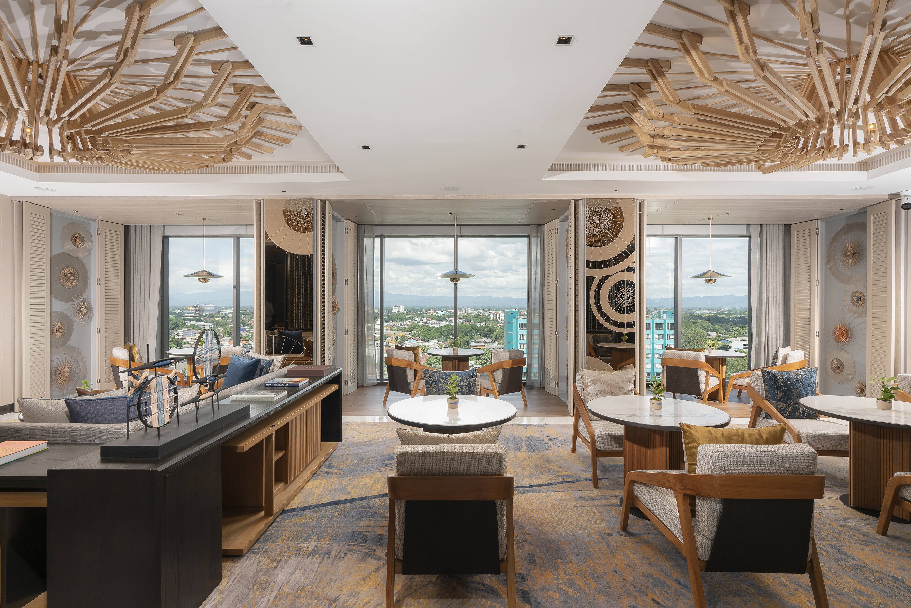 Elegant lounge with city views, geometric wooden ceiling, and stylish seating.