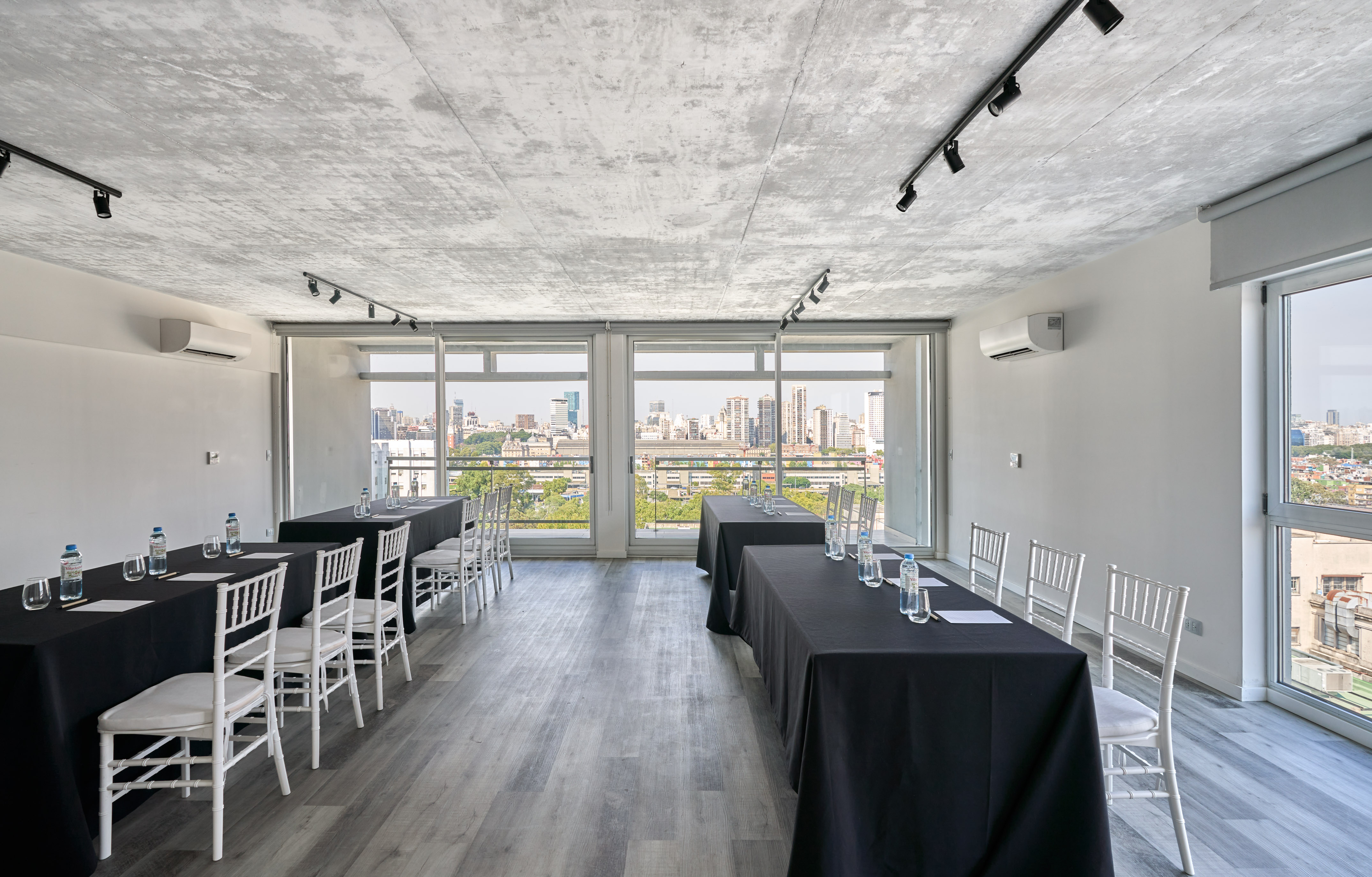 Modern meeting room with black tables, white chairs, and city skyline views. - Dársena - Almarena Puerto Retiro Affiliated by Meliá, ブエノスアイレス