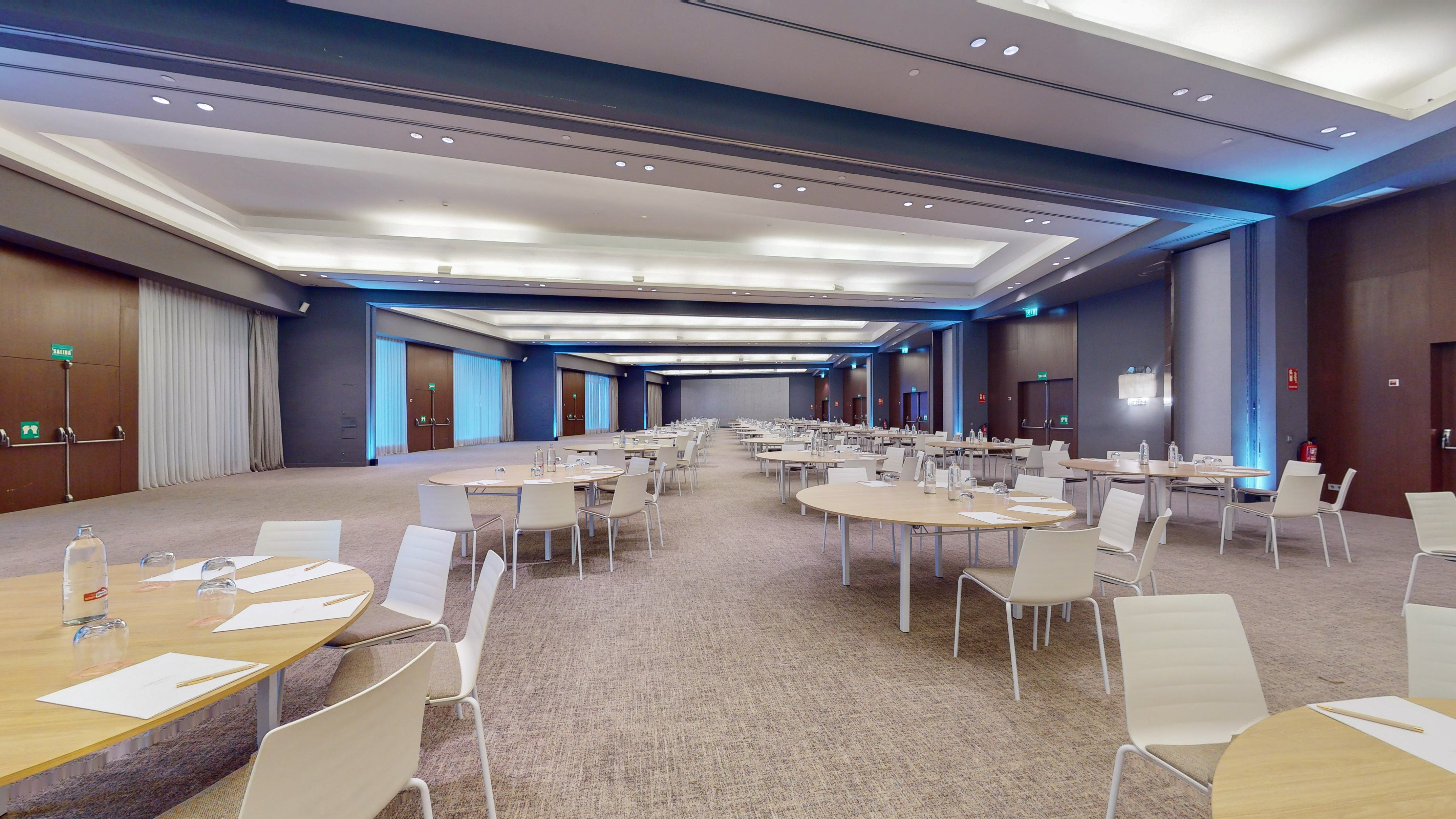 Modern conference room with round tables and chairs, ready for business events.