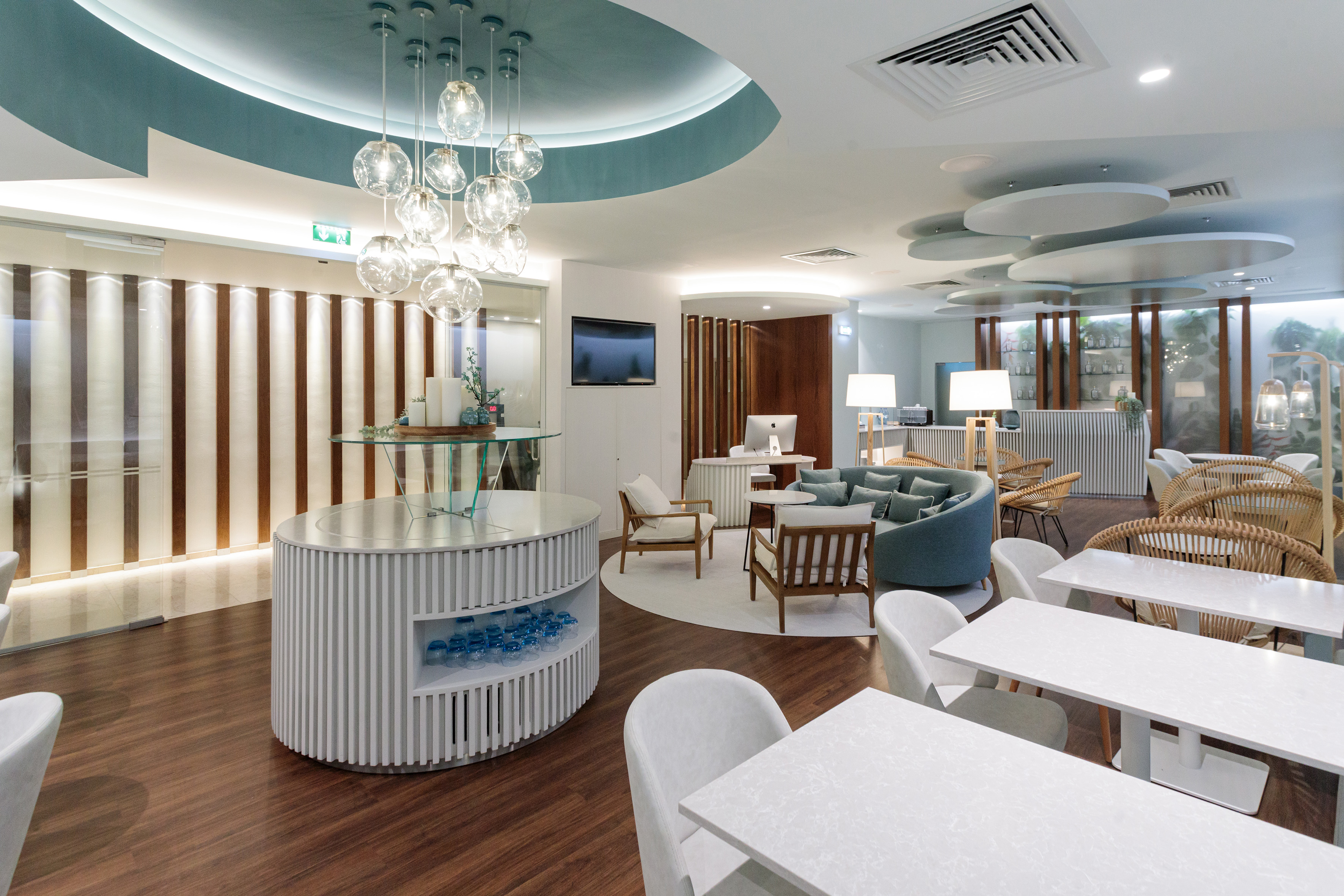 Modern lounge with spherical chandelier, elegant seating, and reception area.